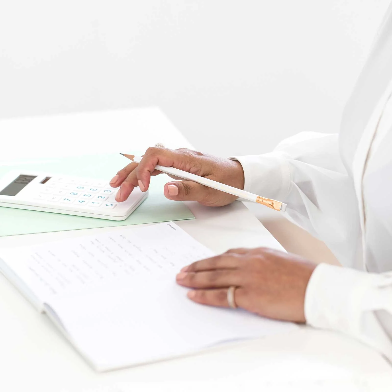 Creative business owner reviewing pricing notes and financial documents at a desk