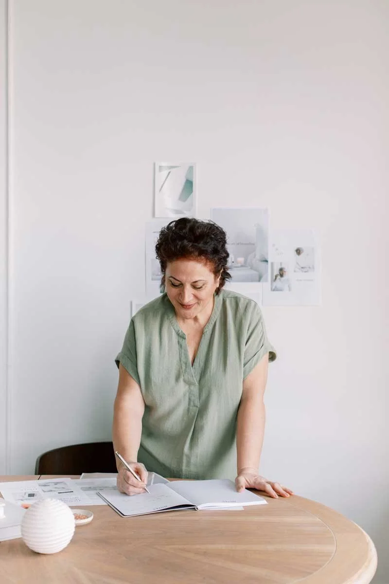 Maker working through a workbook, representing focused lessons and practical tools for a creative business