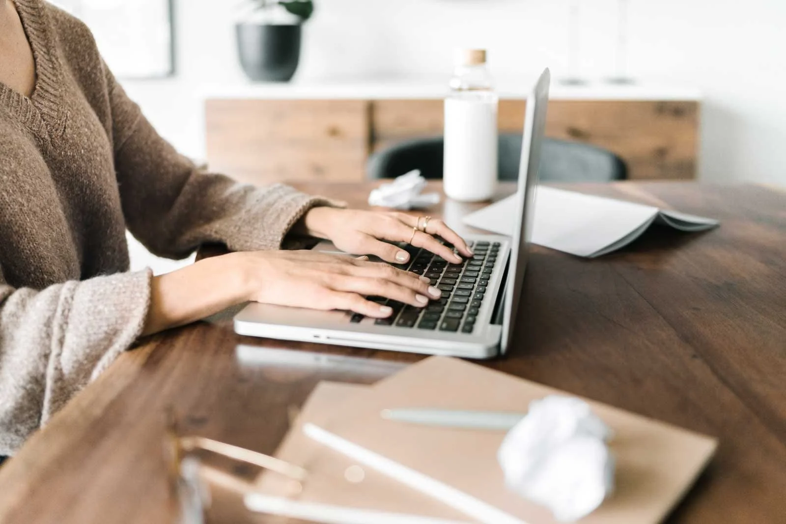 Creative entrepreneur working on a laptop at a desk, representing grounded decision-making and planning supported by a clear business plan