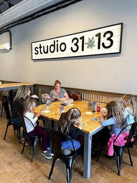 Students gathered around a table during a creative workshop at Studio 31·13.