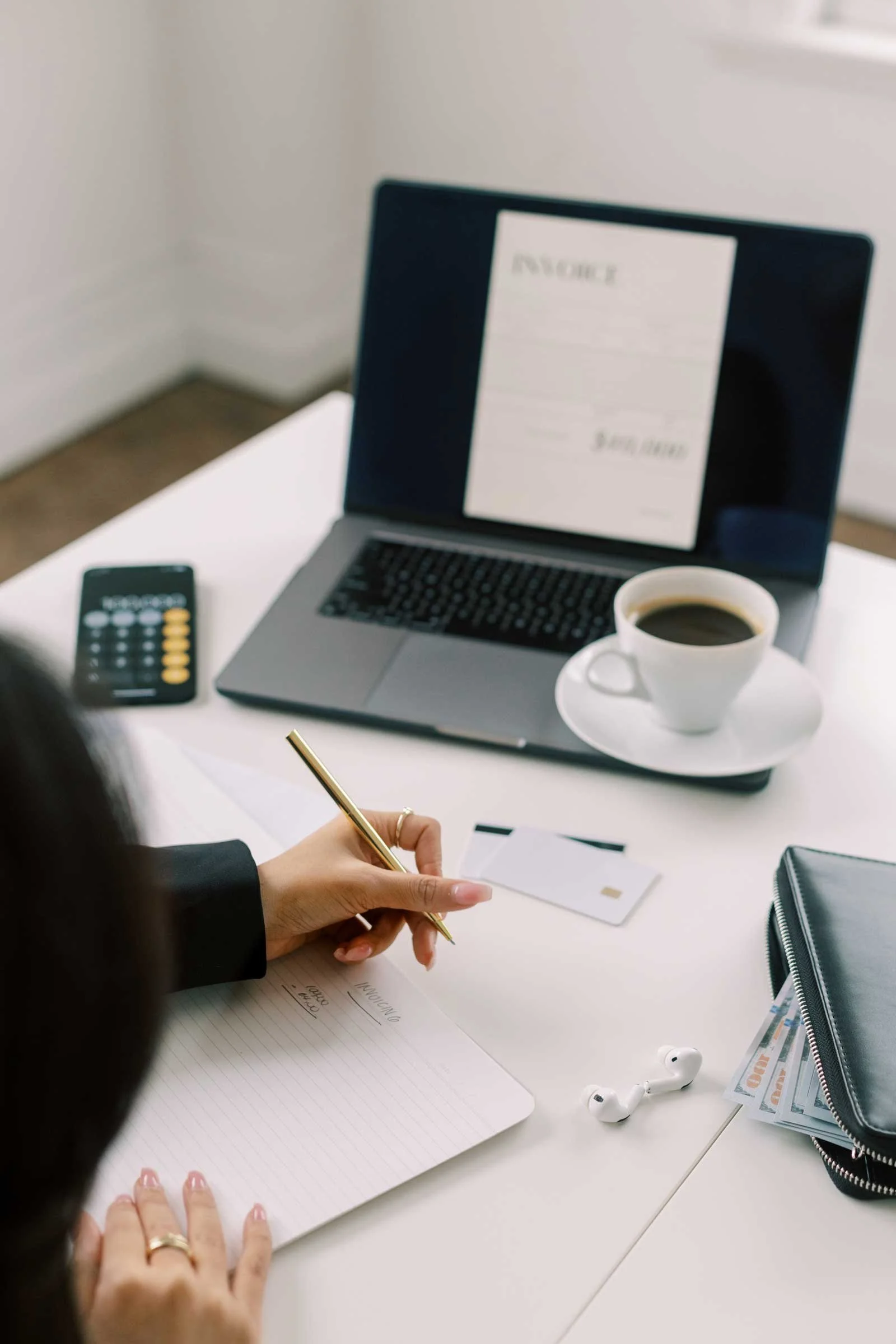 Business owner writing in a notebook at a desk during a creative business strategy session
