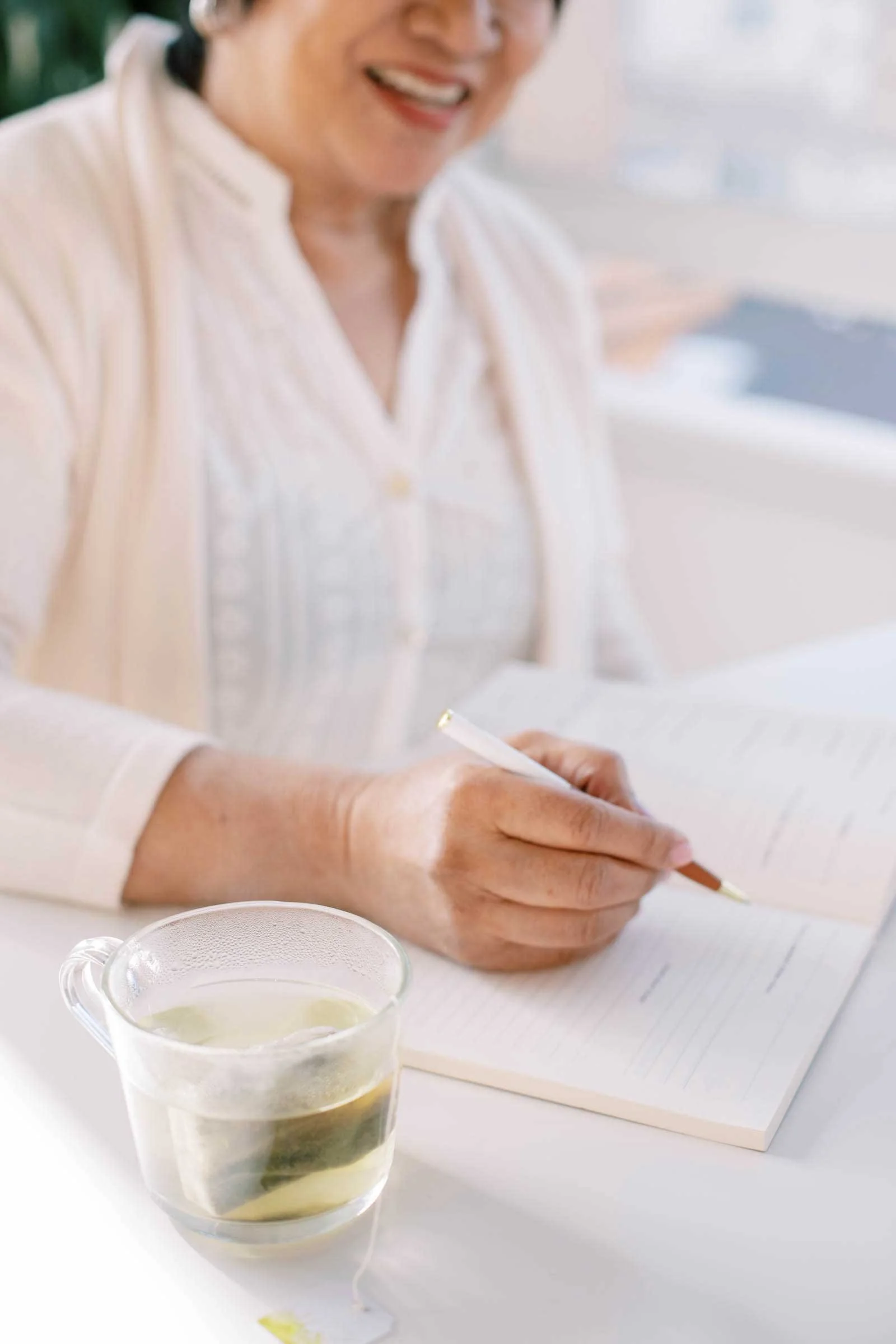 Maker writing in a notebook at a desk while developing a creative business plan