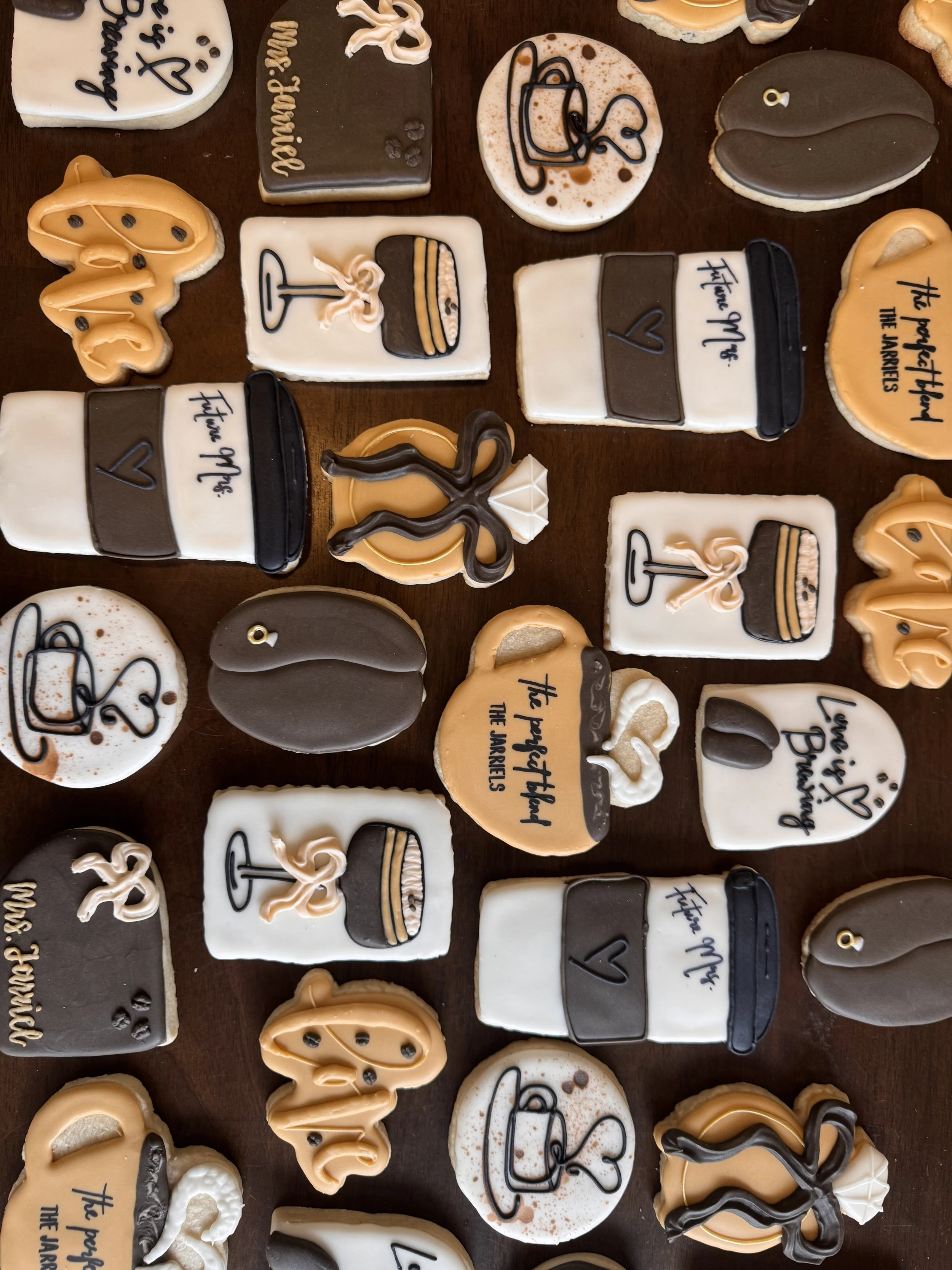 Assorted cookies with coffee-themed and romantic decorations, including coffee cups, hearts, love messages, and abstract designs.