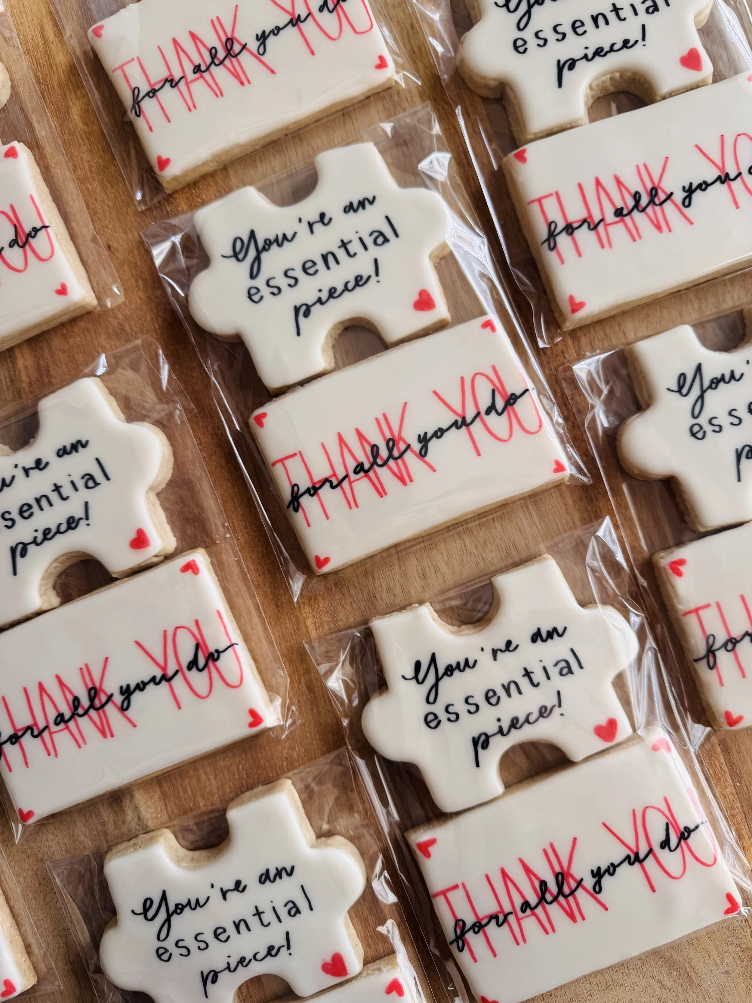 Decorative cookies with messages, some shaped like tissue boxes with 'Thank You' written in red and 'You're an essential piece!' in black, others shaped like tissue boxes with a similar message.