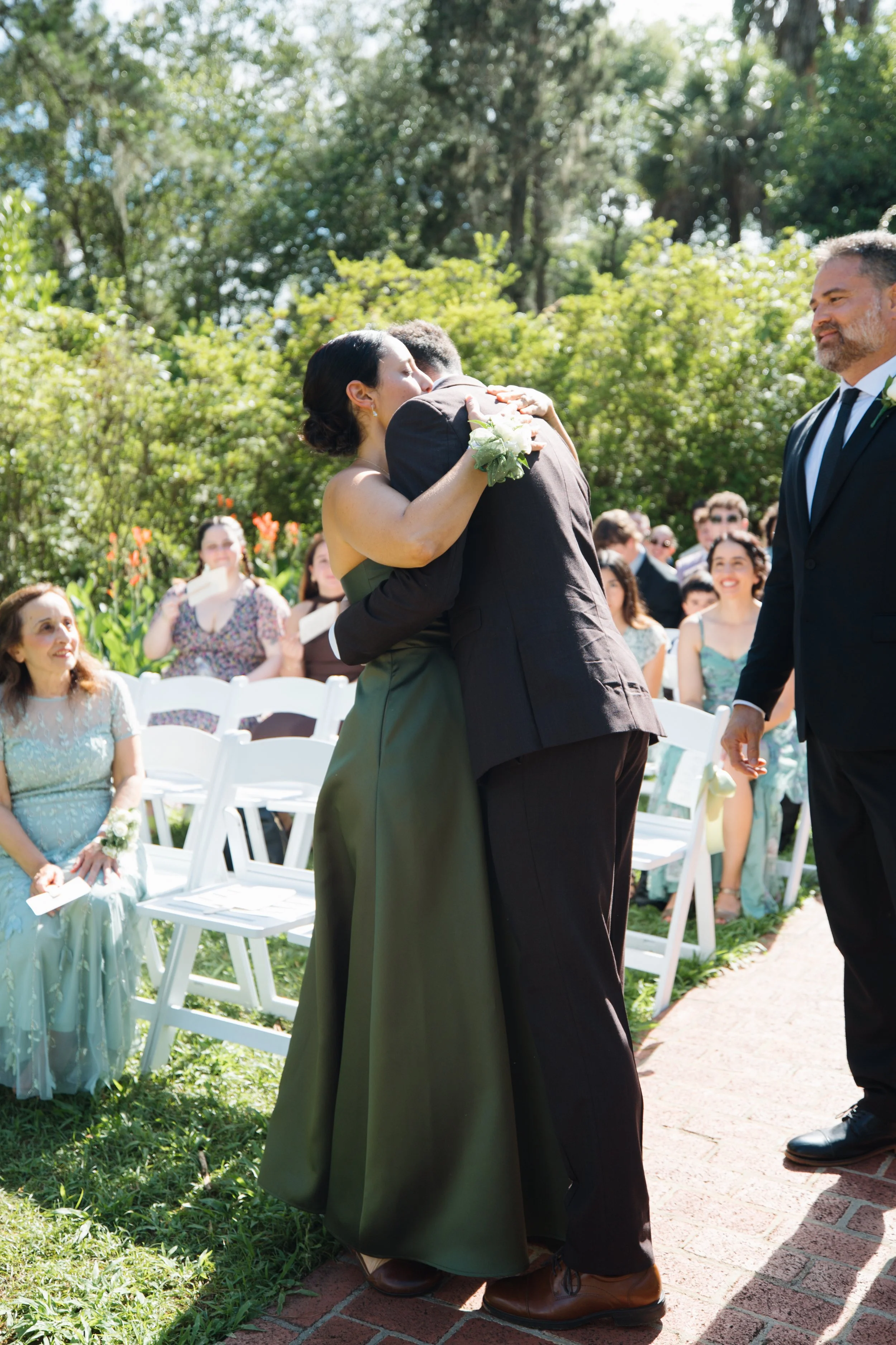 Mother of the groom hugging him after walking down the isle emotional