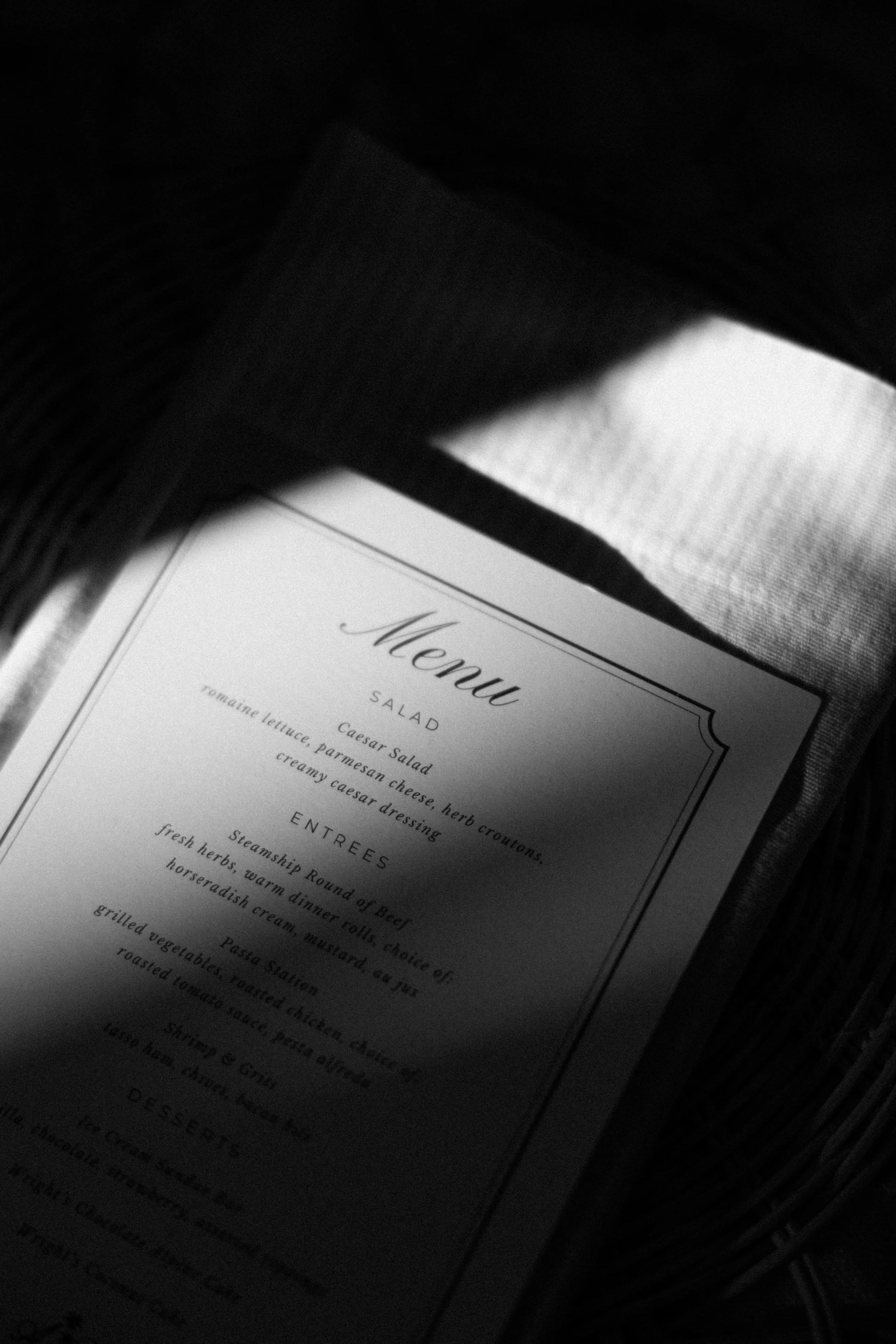 Part of a menu with a list of food items including salads, entrees, and desserts, with text in a serif font on a white background.
