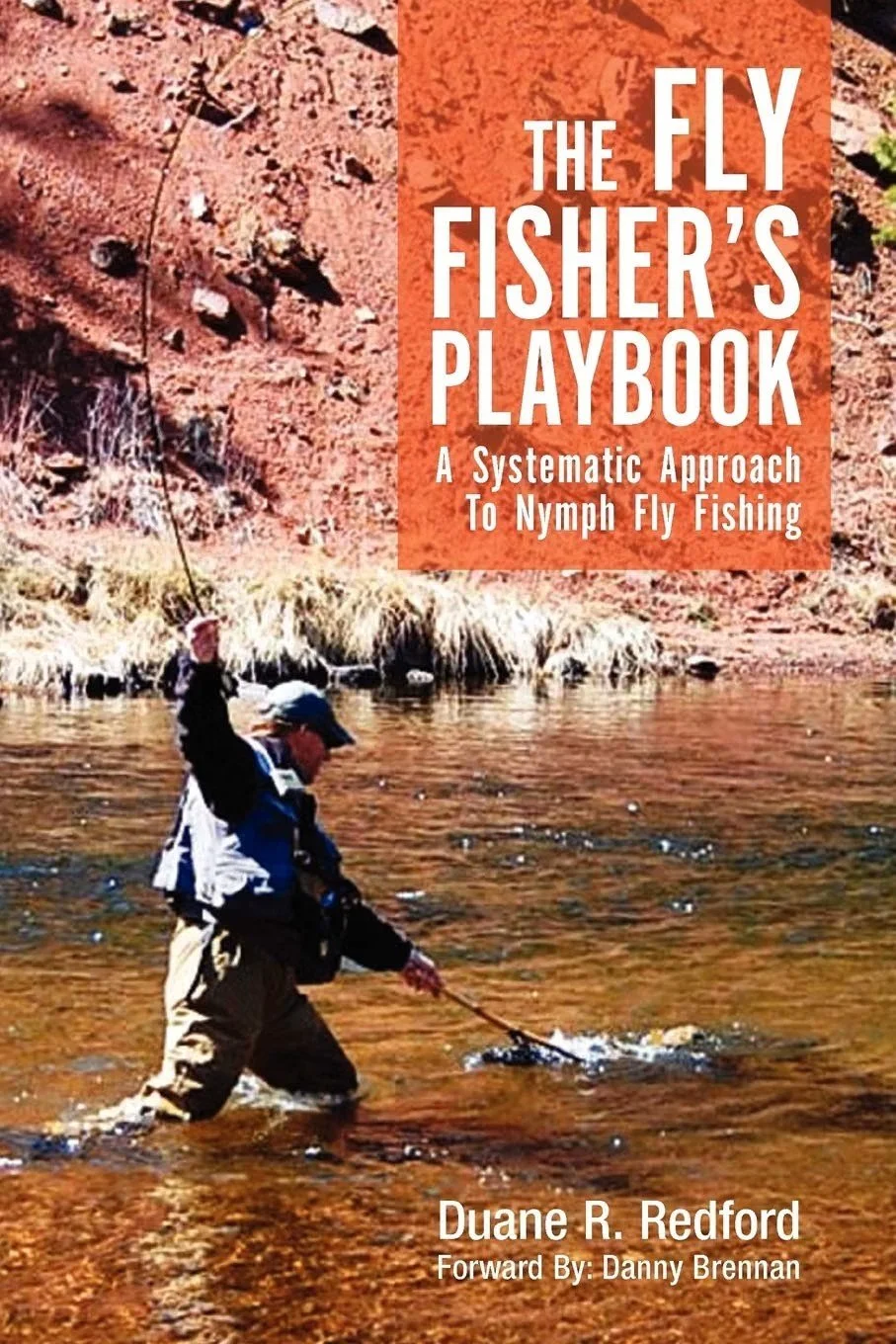 Book cover titled "The Fly Fisher's Playbook: A Systematic Approach To Nymph Fly Fishing" by Duane R. Redford, with a foreword by Danny Brennan. The cover features a photo of a person fly fishing in a river with a rocky, desert-like terrain in the background.