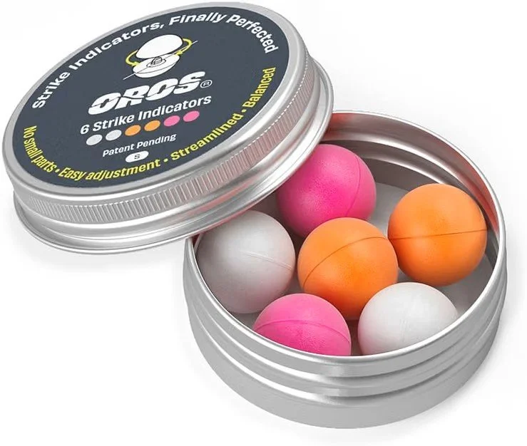 Open round metal tin containing six colorful pool cue chalks in pink, white, and orange.