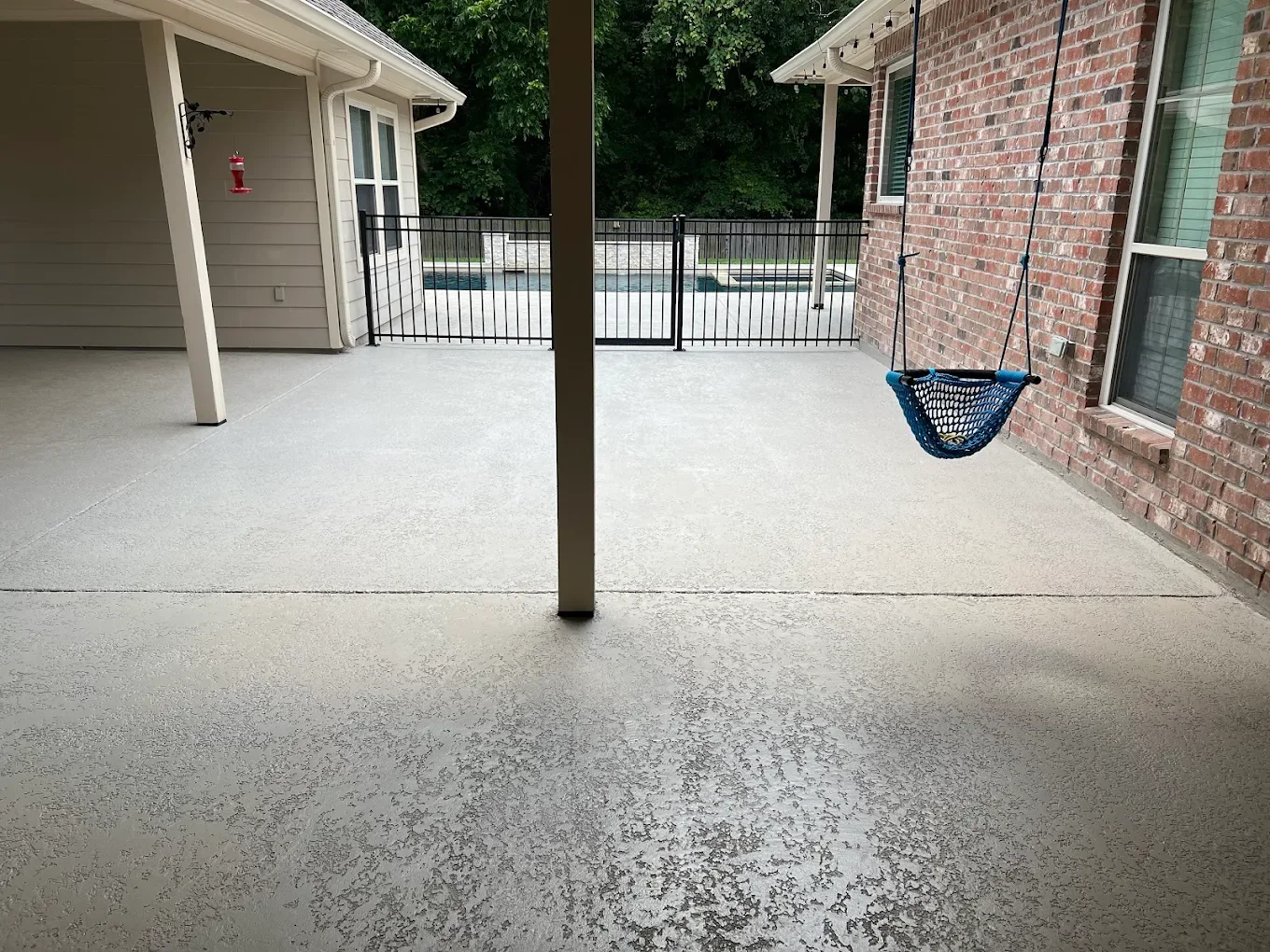 Covered patio next to a pool resurfaced with a slip-resistant knockdown texture overlay by C&C Concrete Design