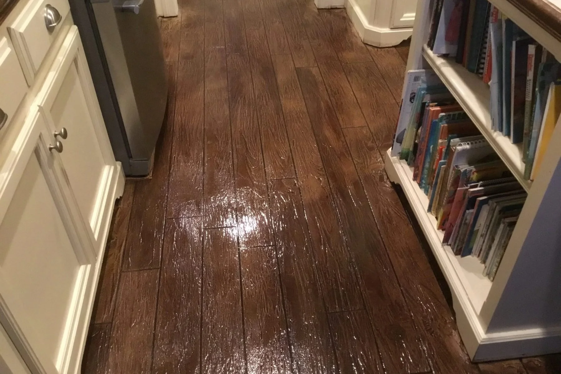 Hand-carved and stained wood-look concrete overlay on an interior floor