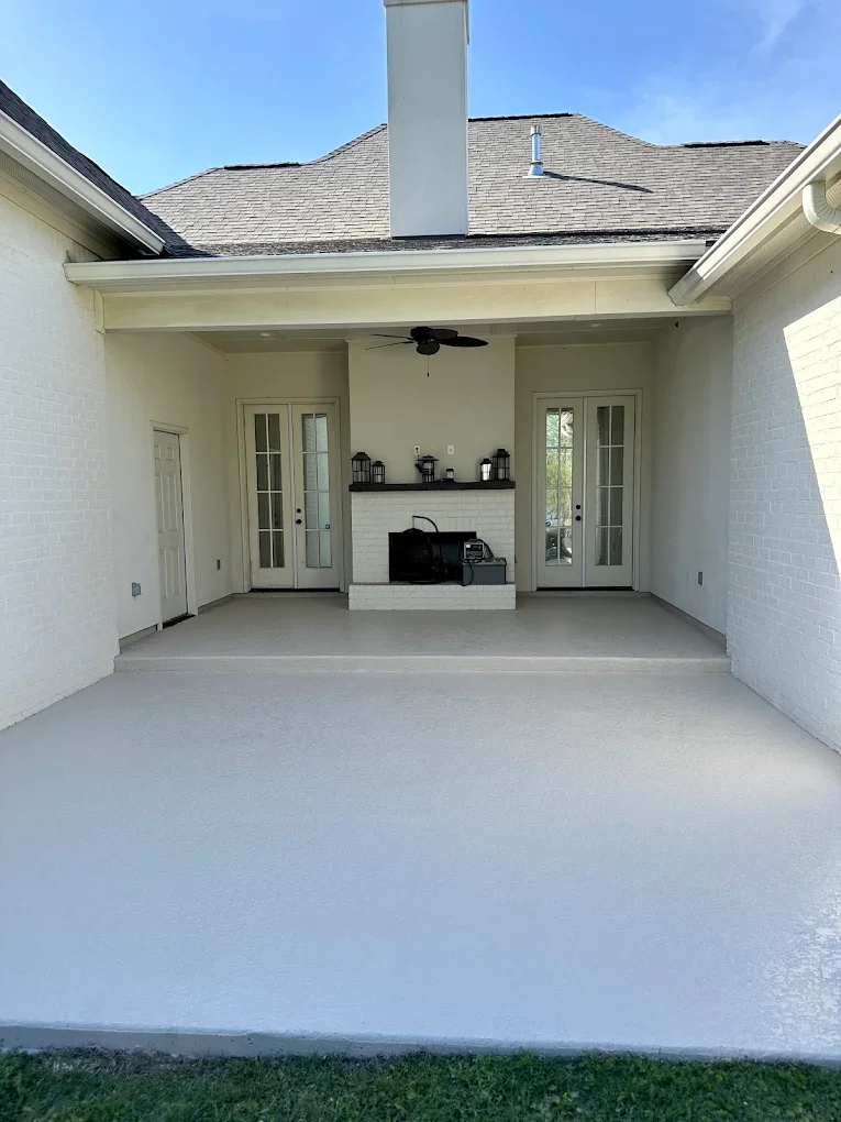 Covered back patio finished with a light gray spray texture concrete overlay by C&C Concrete Design