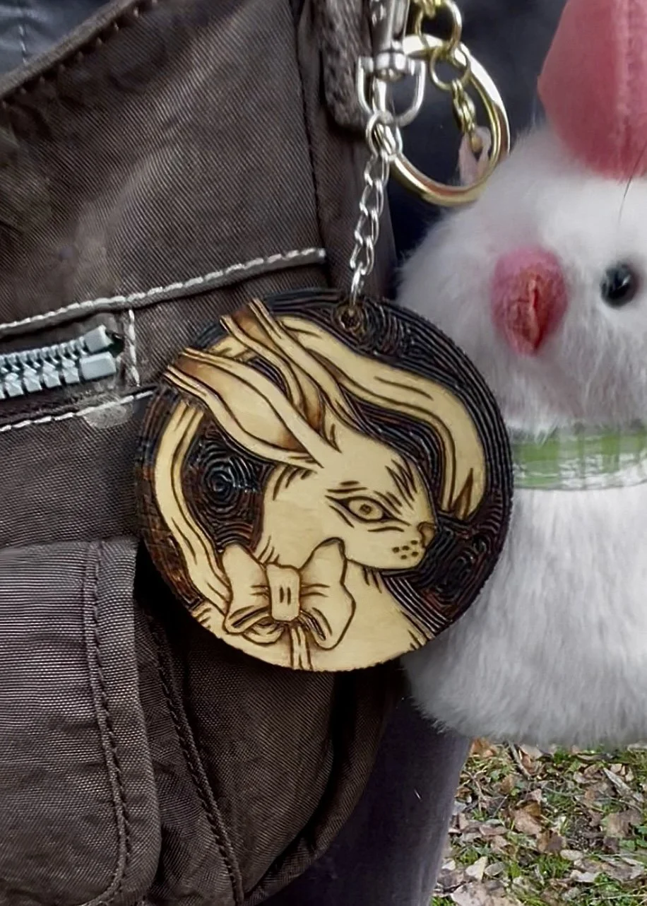 Porte-clé en bois artisanal pyrogravé à la main représentant un petit lapin mignon portant un nœud girly accroché à un sac y2k.