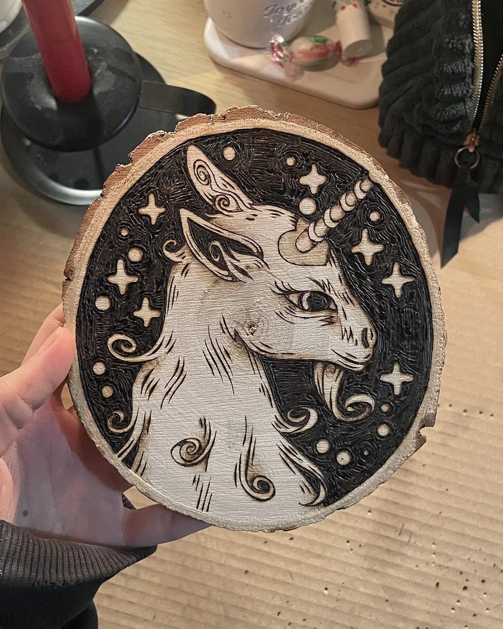 Petite pyrogravure artisanale faite main sur bois brut représentant une licorne inspirée des légendes et des bestiaires médiévaux dans un atelier d'artiste.
