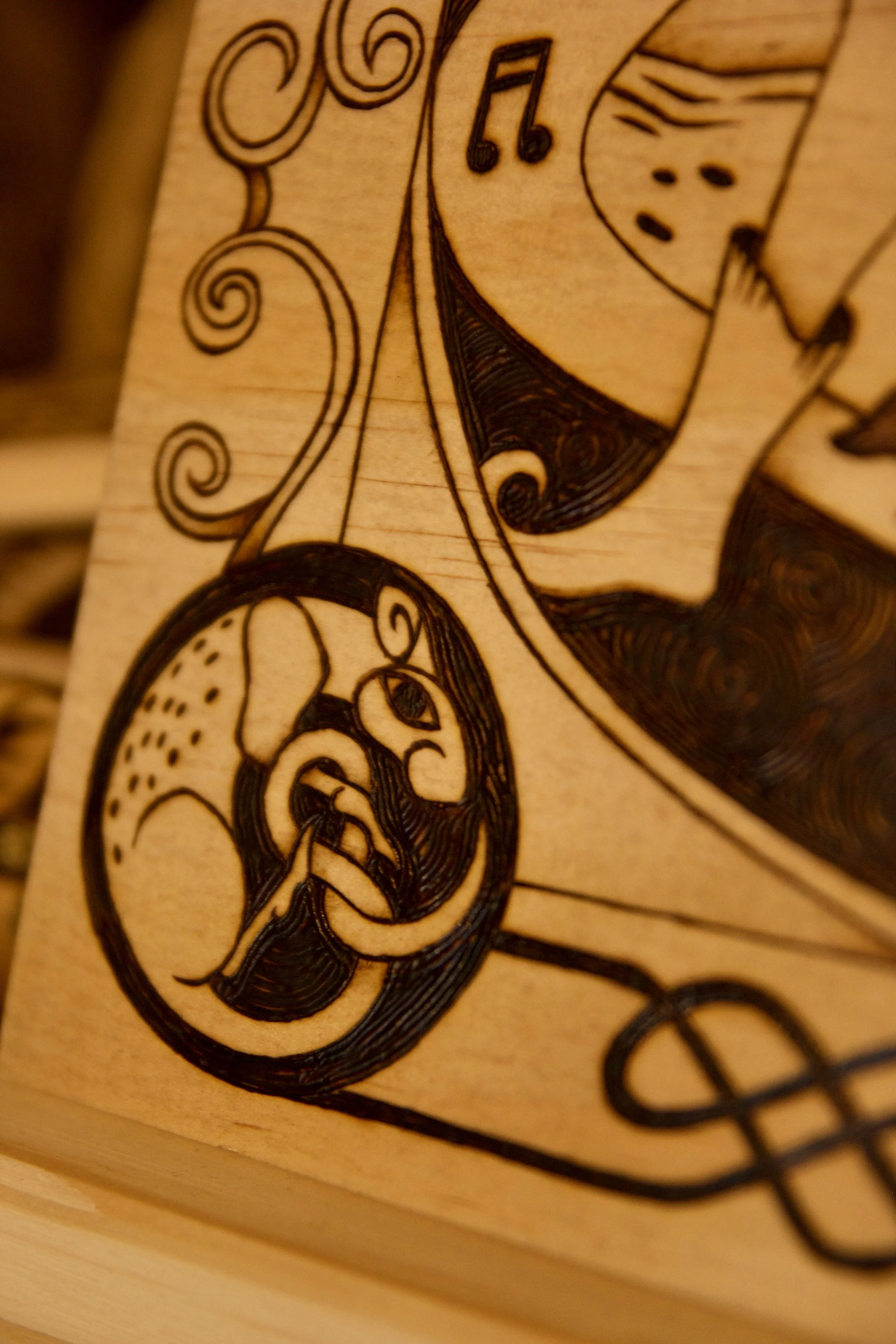 Motif celtique rat sur une pyrogravure carrée sur bois représentant le joueur de flûte de Hamelin guidant les rats, entourée d'entrelacs médiévaux.