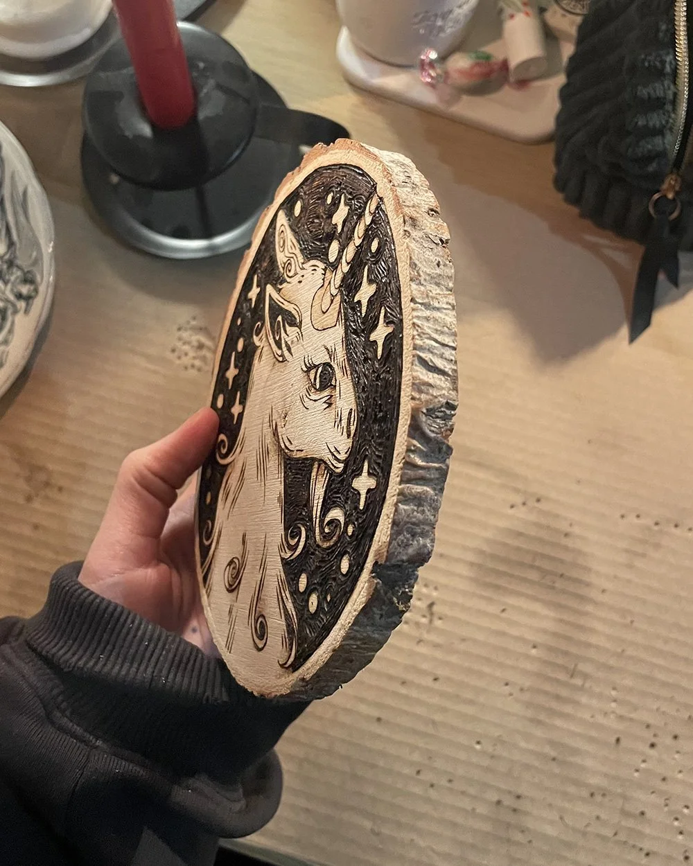 Vue de la tranche d'une petite pyrogravure artisanale faite main sur bois brut représentant une licorne inspirée des légendes et des bestiaires médiévaux.