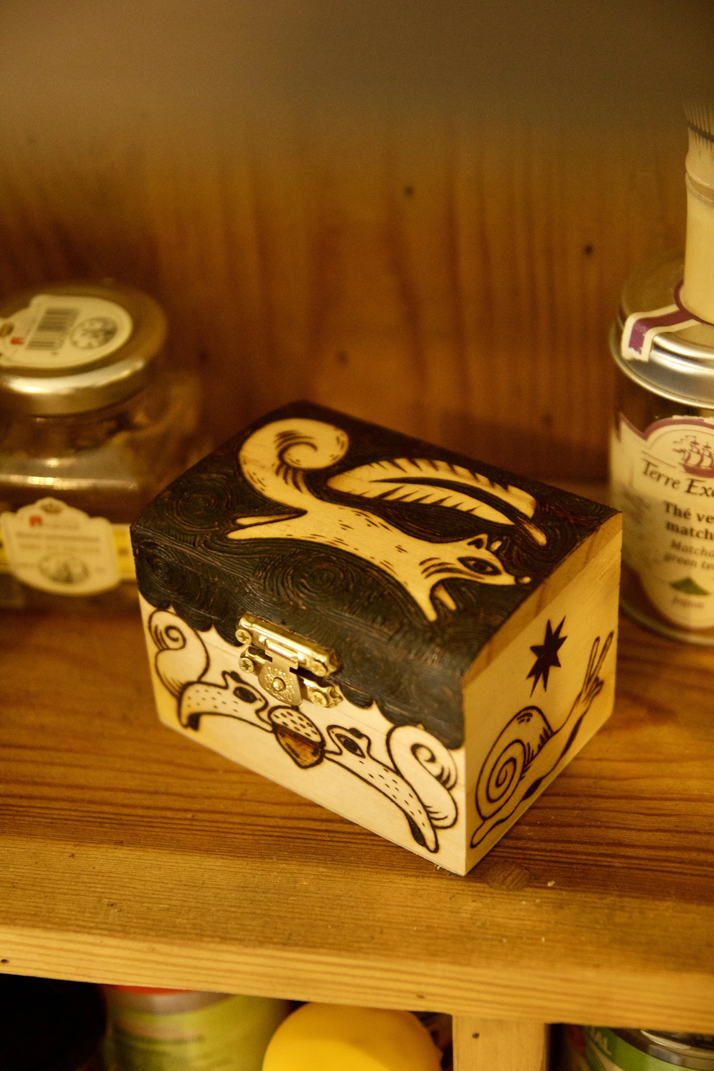 Petite boîte en bois mystique pyrogravée main, illustrée avec des écureuils, un renard, un oiseau et les phases de la lune vue de dessus.