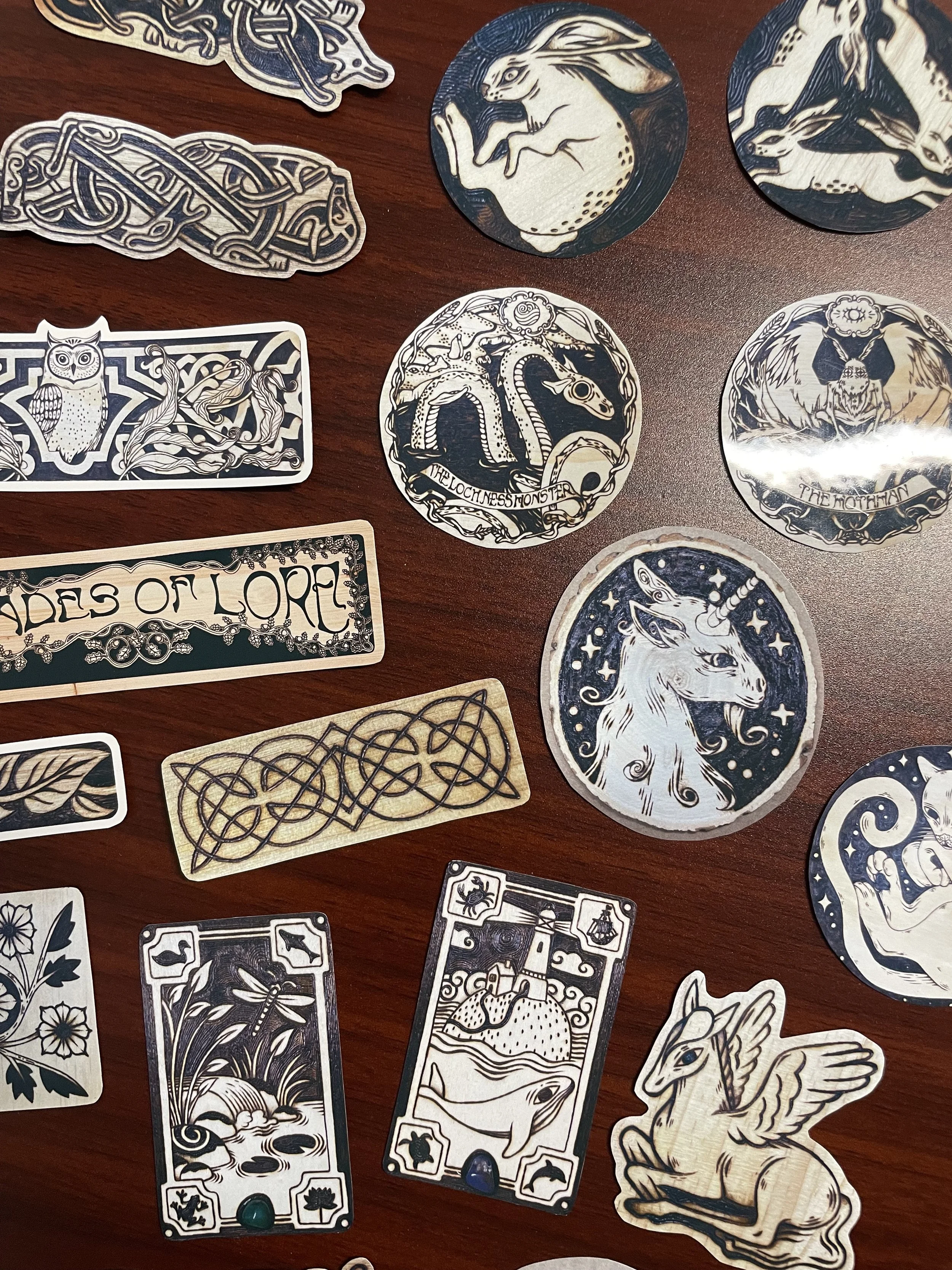 Pack de 23 stickers en vrac illustrés brillants aux tons chauds de bois, représentant des animaux de la forêt et des symboles mystiques inspirés de pyrogravures.