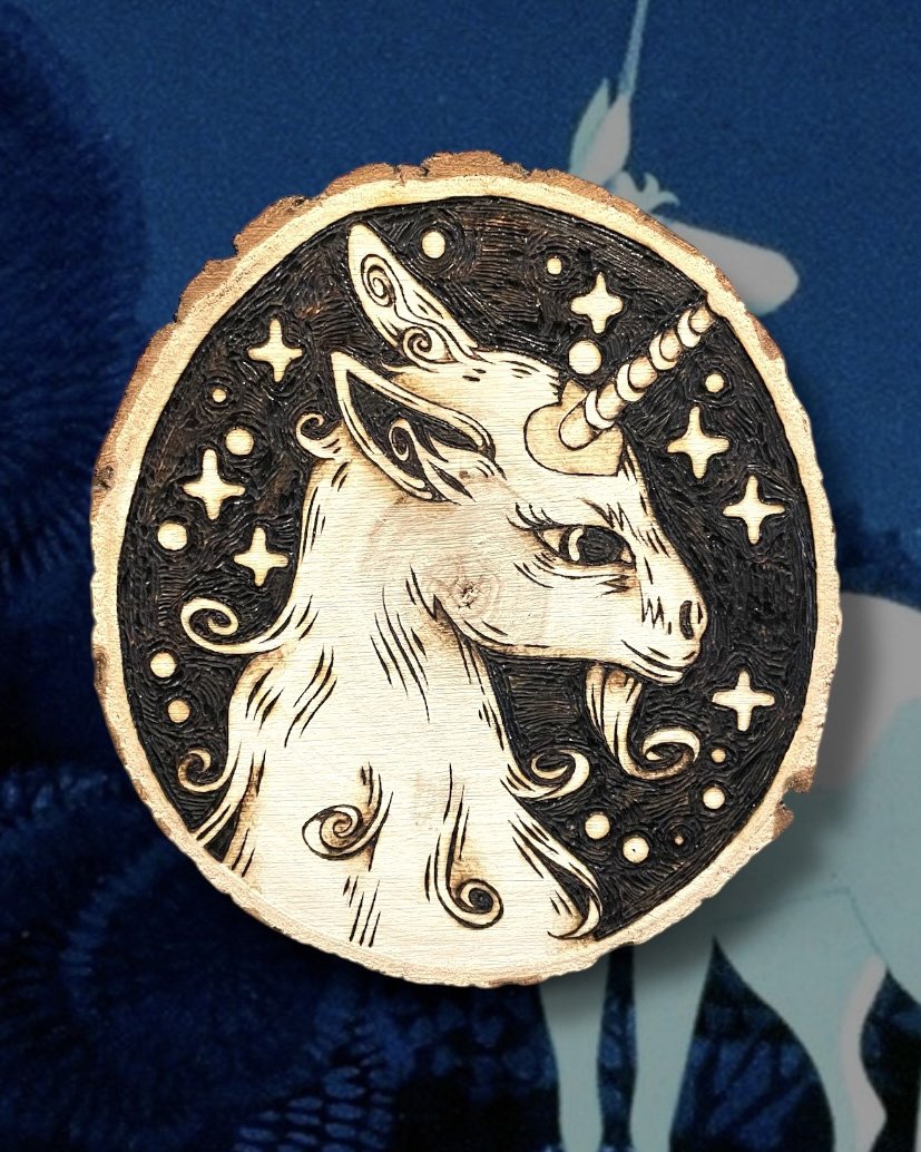 Petite pyrogravure artisanale faite main sur bois brut représentant une licorne inspirée des légendes et des bestiaires médiévaux avec the last unicorn en fond.