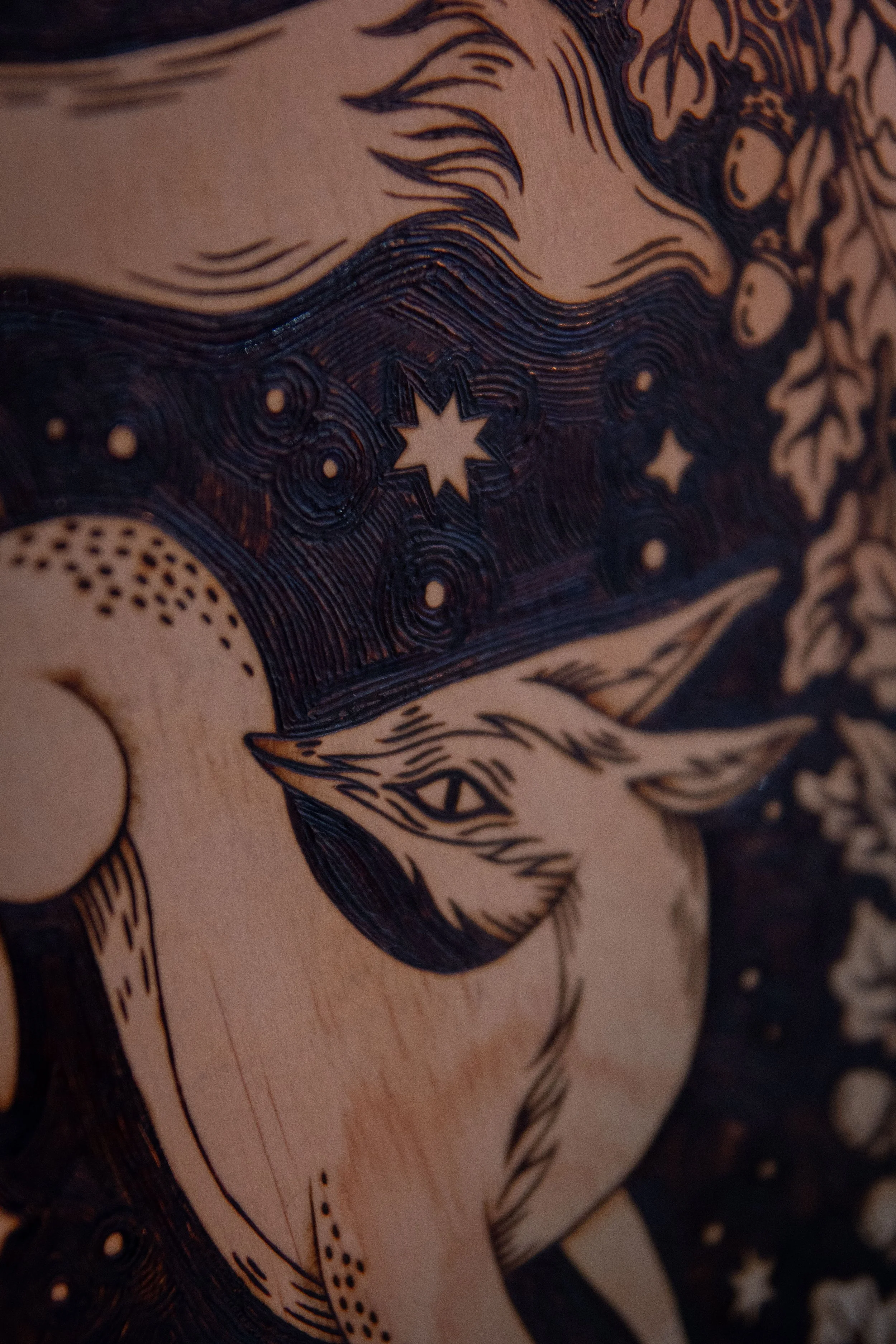 Détail sur une plaque en bois artisanale finement pyrogravée à la main, représentant un renard mystique aux détails ombrés au cœur de la forêt.