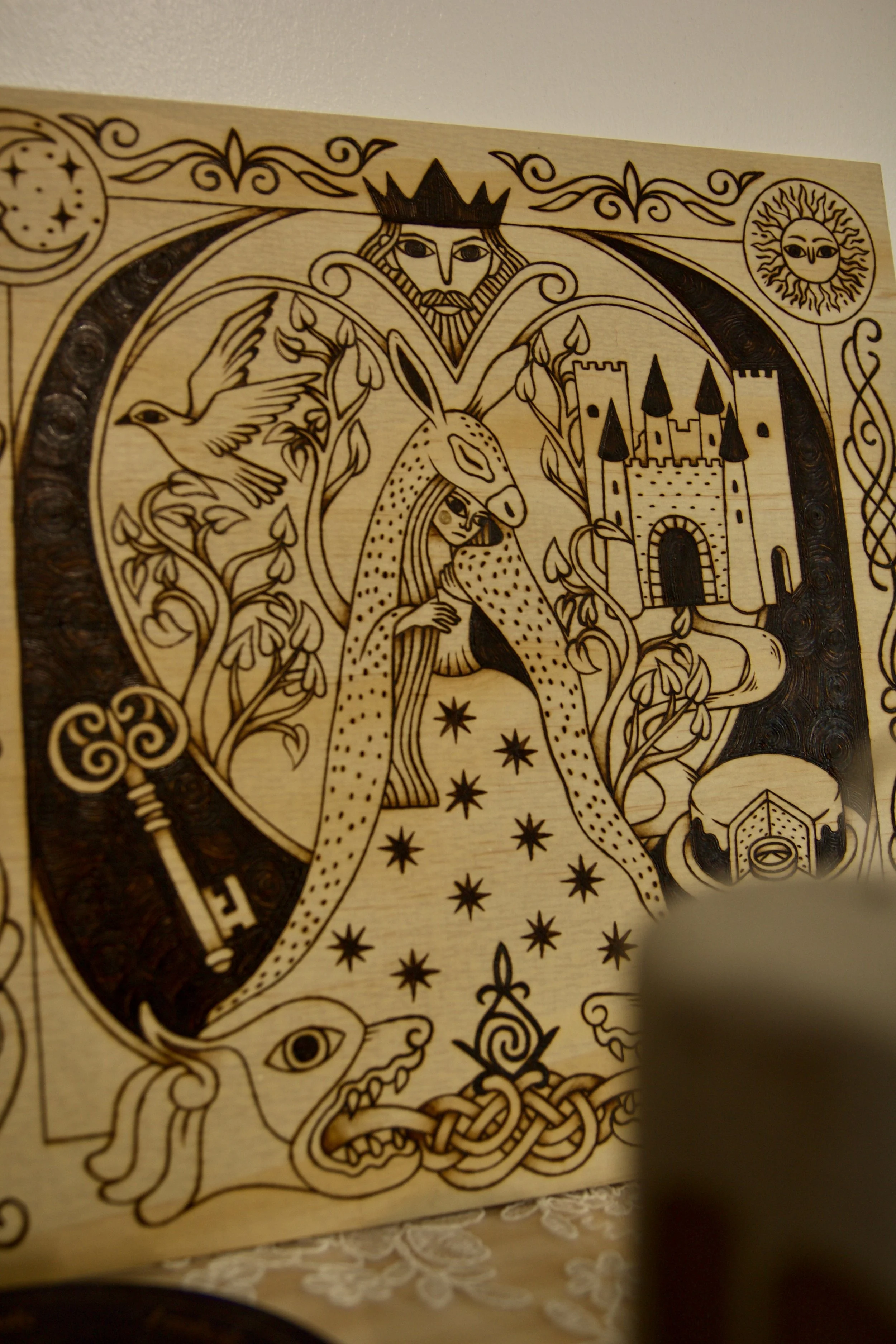 Gravure carré en bois pyrogravé à la main représentant une illustration du conte Peau d’Âne inspirée du style des enluminures médiévales.