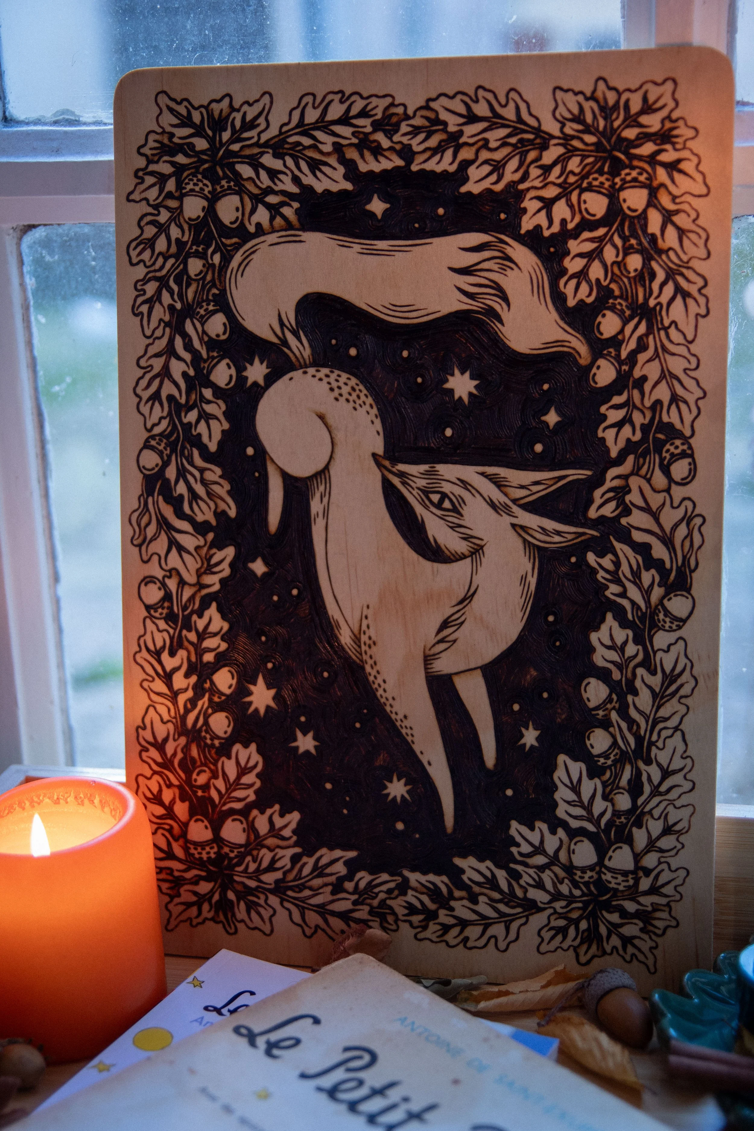 Plaque en bois artisanale finement pyrogravée à la main, représentant un renard mystique aux détails ombrés au cœur de la forêt éclairée à la bougie.
