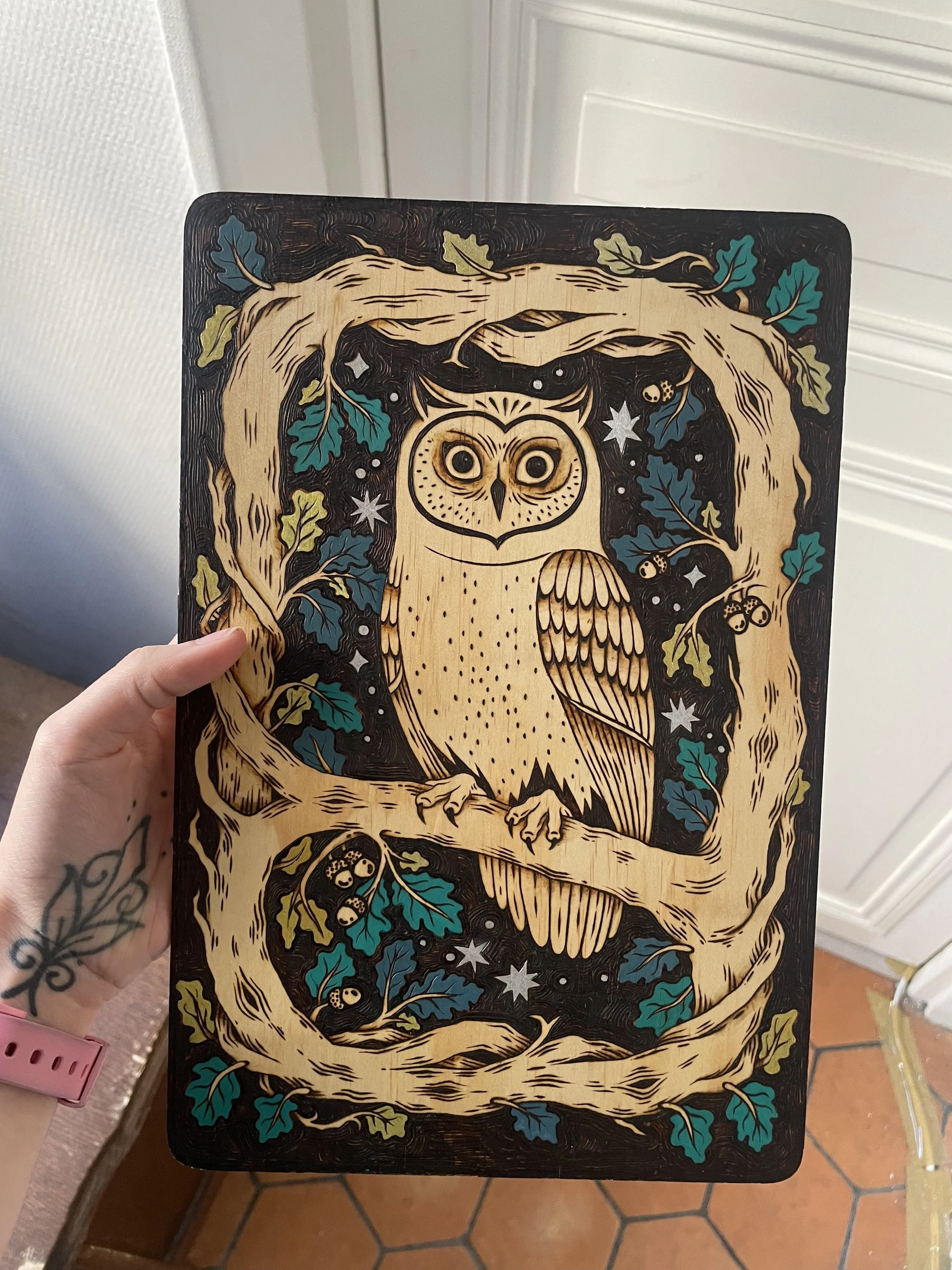 Plaque décorative artistique en bois gravée à la main représentant un hibou mystique, avec de délicats détails colorés à la peinture acrylique.