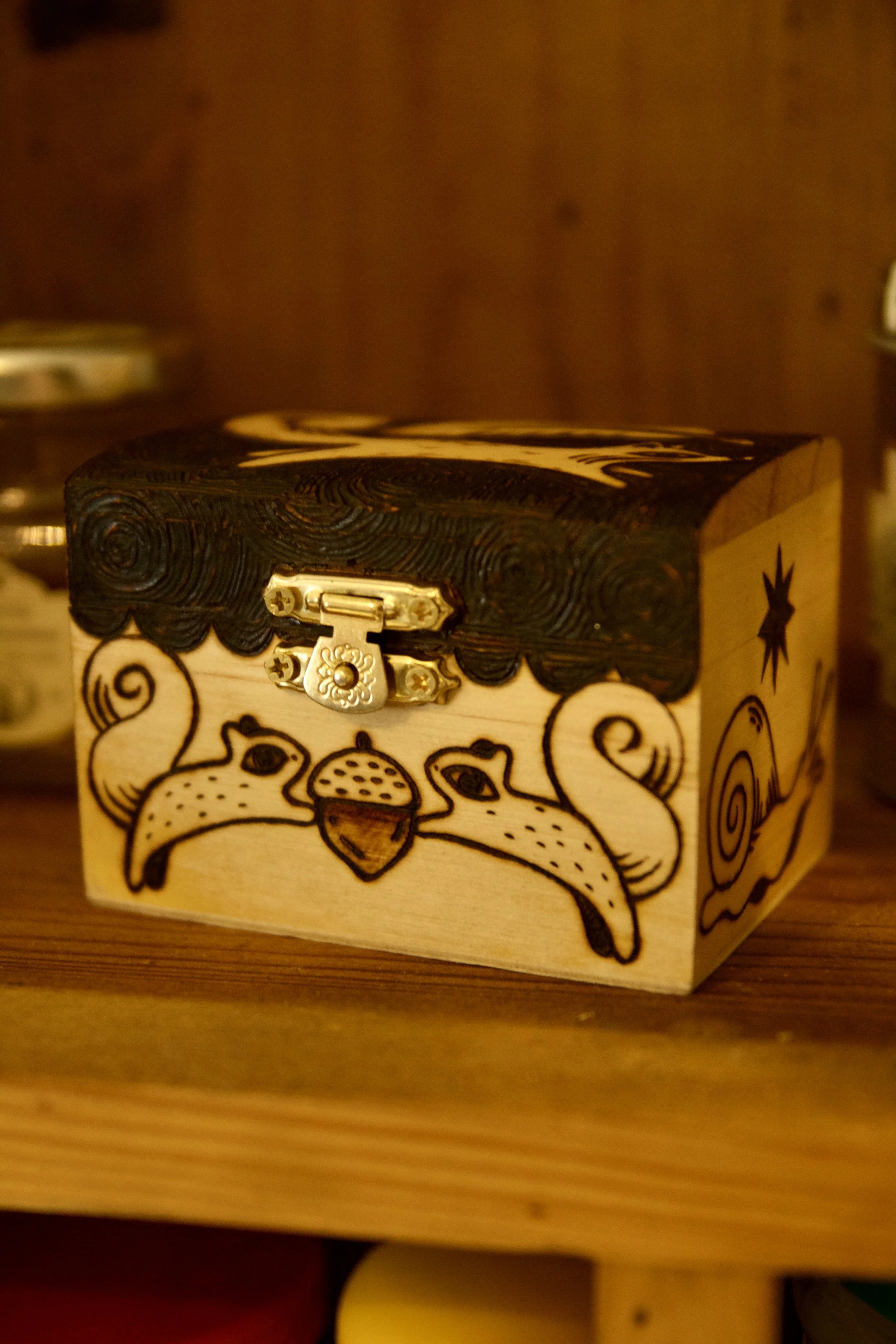 Petite boîte en bois mystique pyrogravée main, illustrée avec des écureuils, un renard, un oiseau et les phases de la lune vue de face.