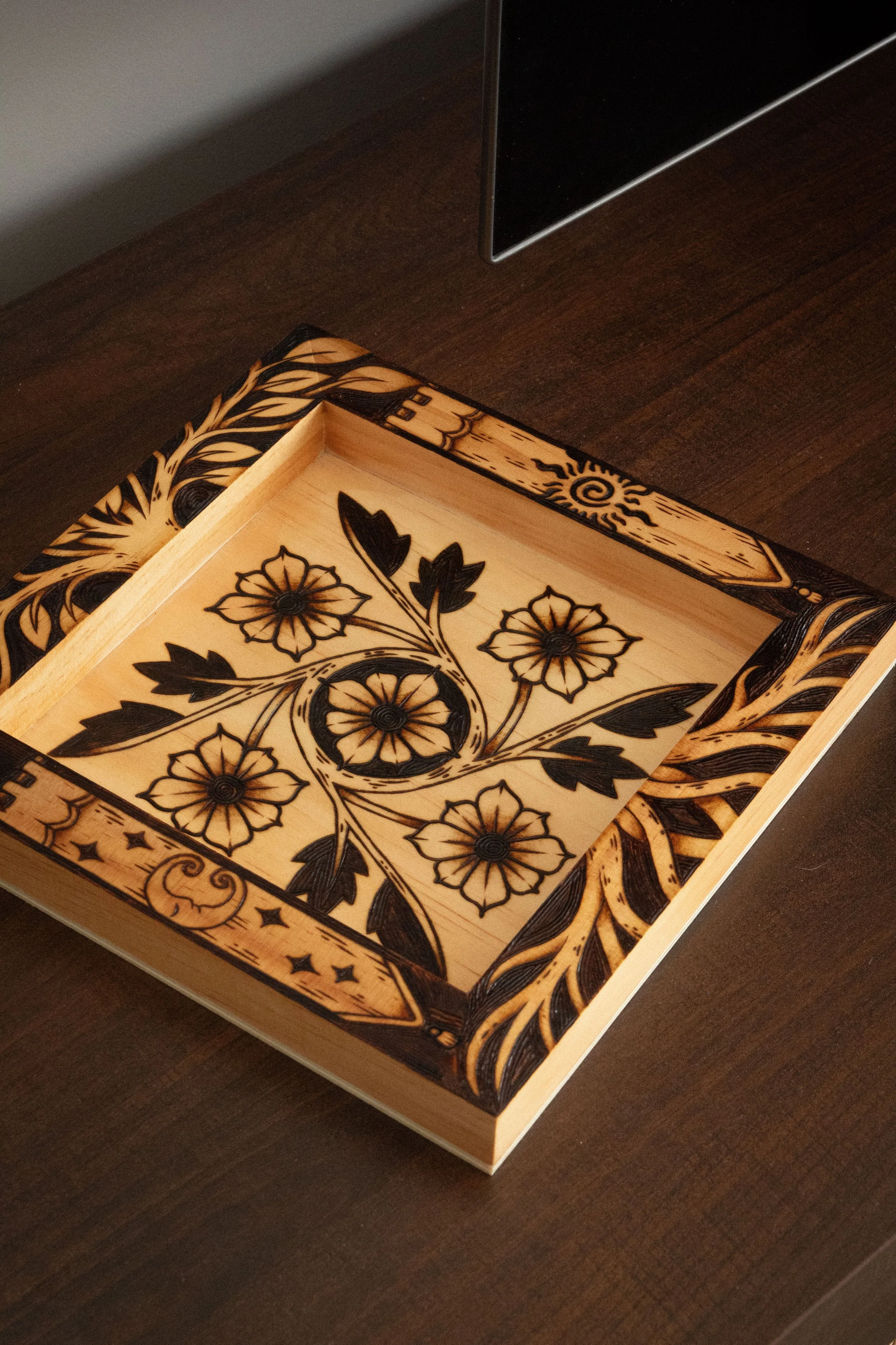 Plateau vide-poche carré en bois clair pyrogravé à la main avec des motifs de fleurs, d'entrelacs celtiques, d'un soleil et d'un croissant de lune mystique.
