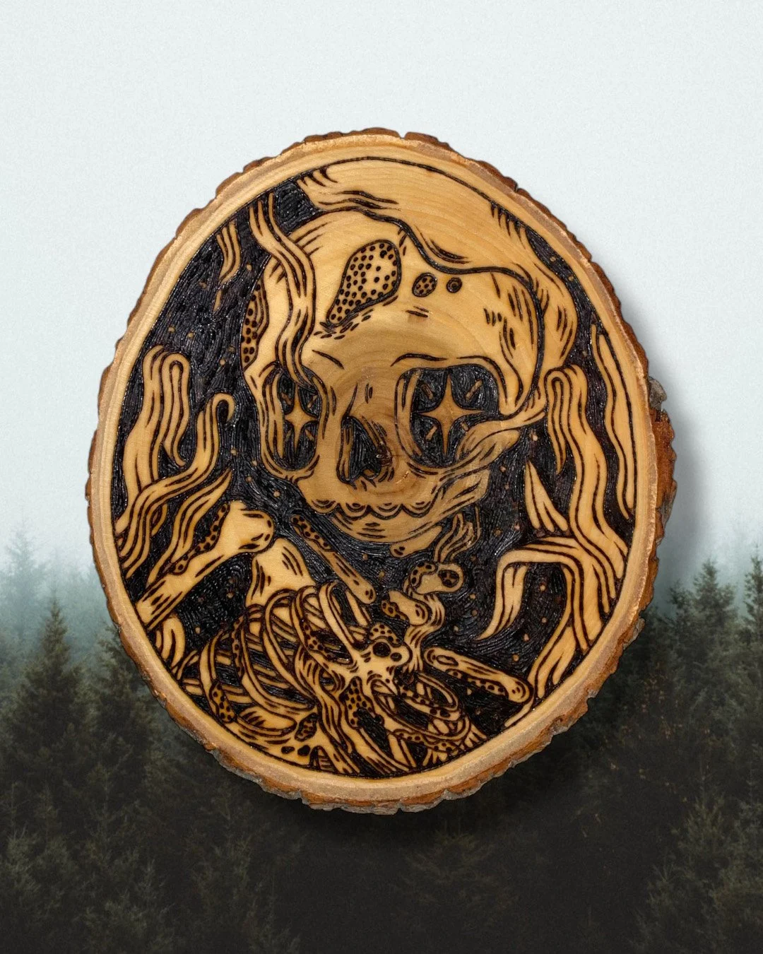 Pyrogravure artisanale sur bois brut ovale représentant un squelette Memento Mori au style d'un artefact ancien avec un font de forêt.