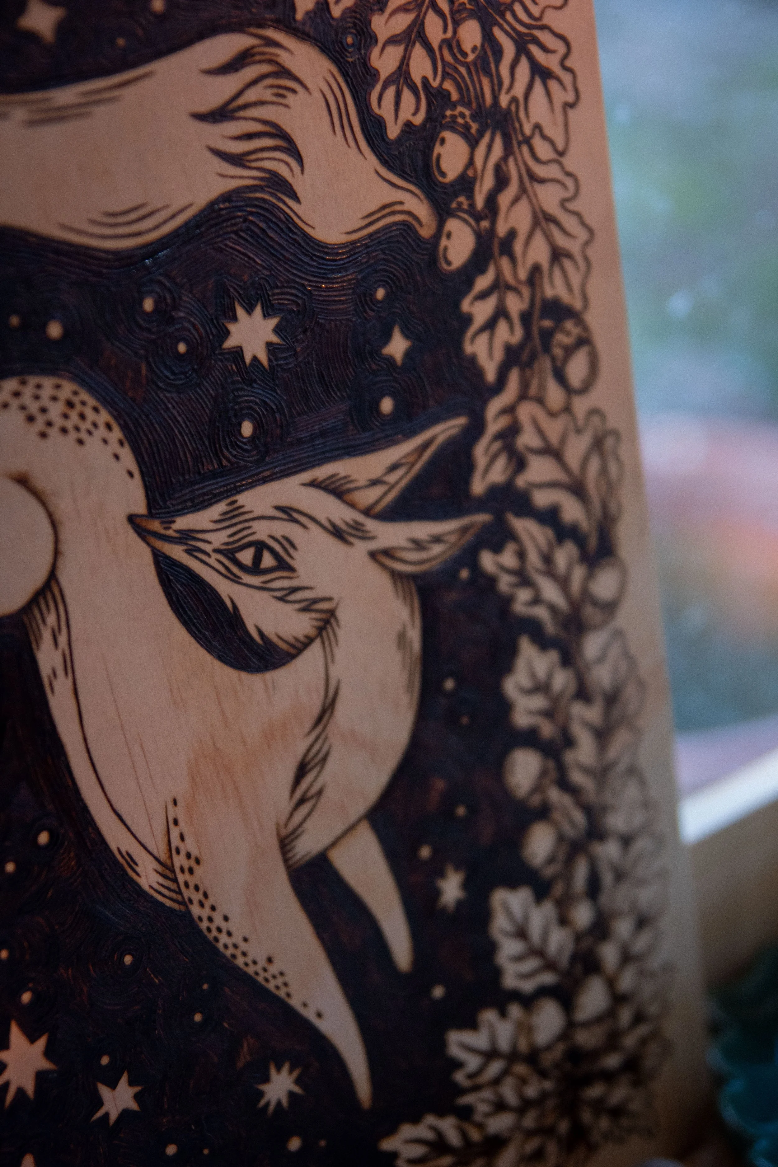 Zoom sur une plaque en bois artisanale finement pyrogravée à la main, représentant un renard mystique aux détails ombrés au cœur de la forêt.