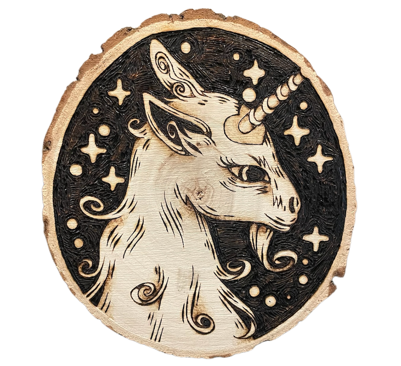 Travail de pyrogravure représentant une licorne avec des étoiles et des motifs magiques, sur une tranche de bois brut.
