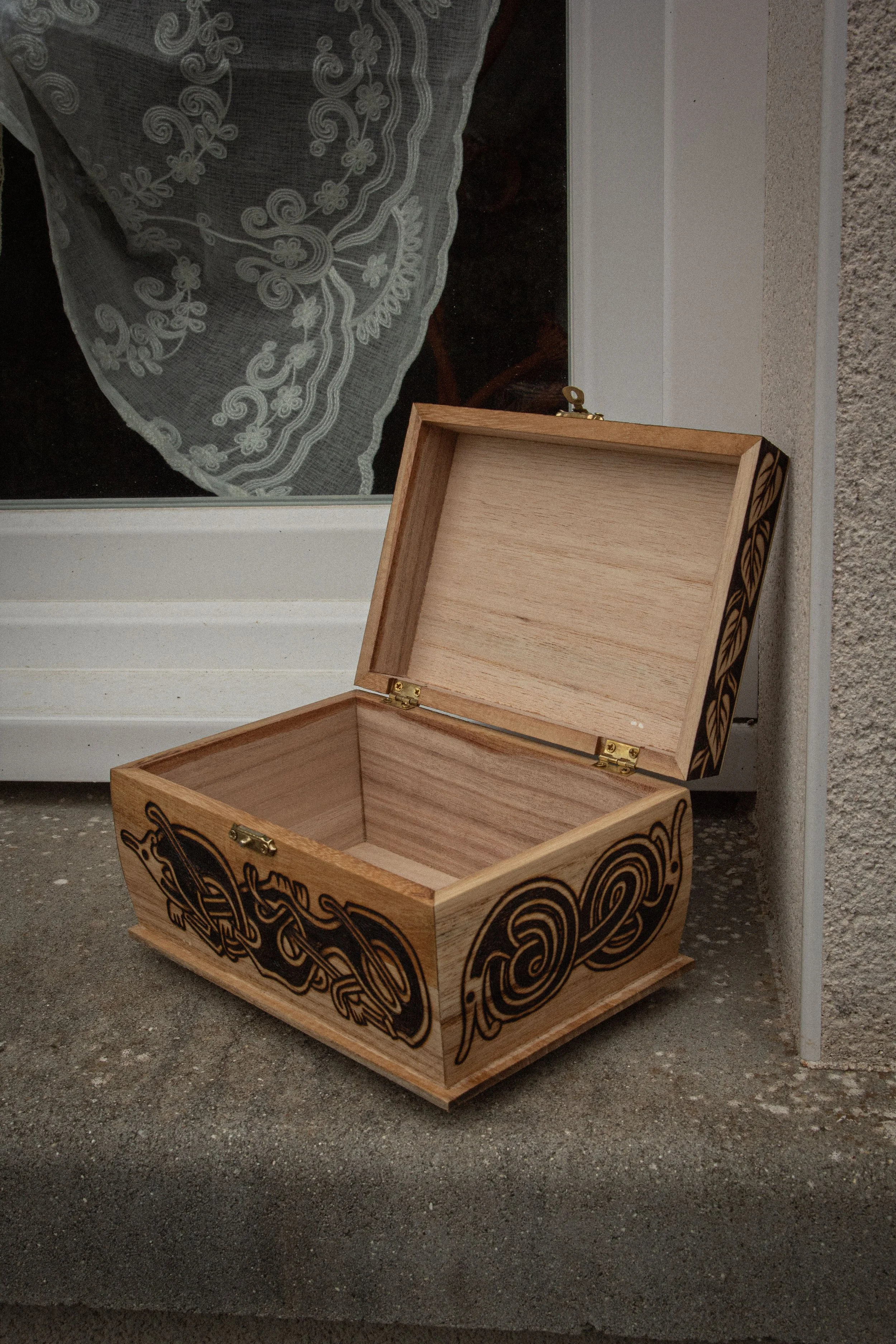 Boîte ouverte en bois pyrogravée à la main représentant un hibou entouré de branches entrelacées et de motifs celtiques.