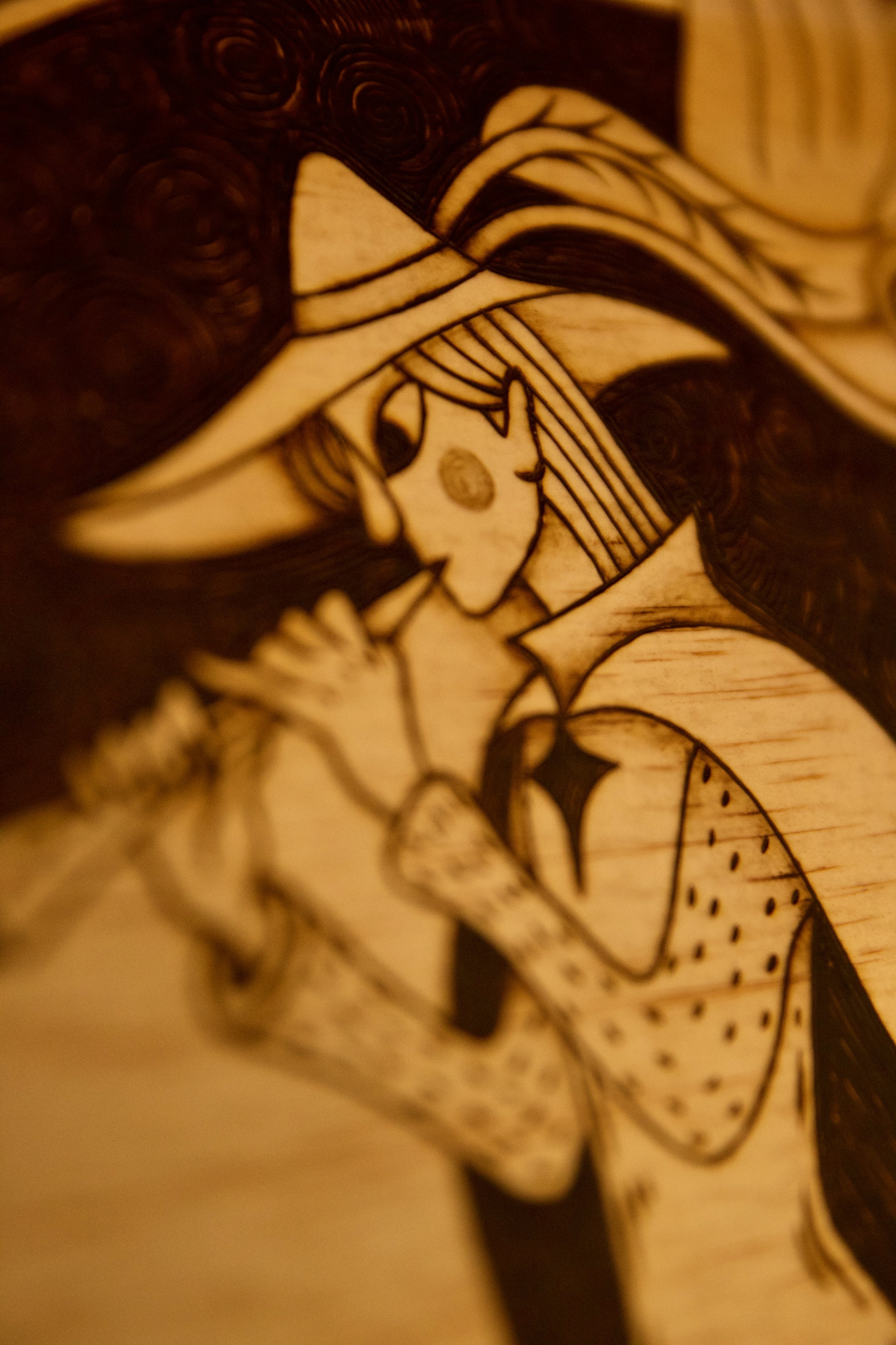 Zoom sur le visage du joueur de flûte - Grande pyrogravure carrée sur bois représentant le joueur de flûte de Hamelin guidant les rats, entourée d'entrelacs médiévaux.