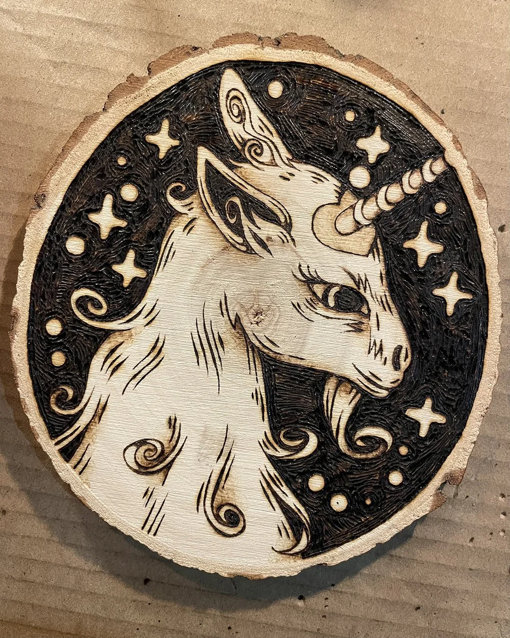 Petite pyrogravure artisanale faite main sur bois brut représentant une licorne inspirée des légendes et des bestiaires médiévaux.