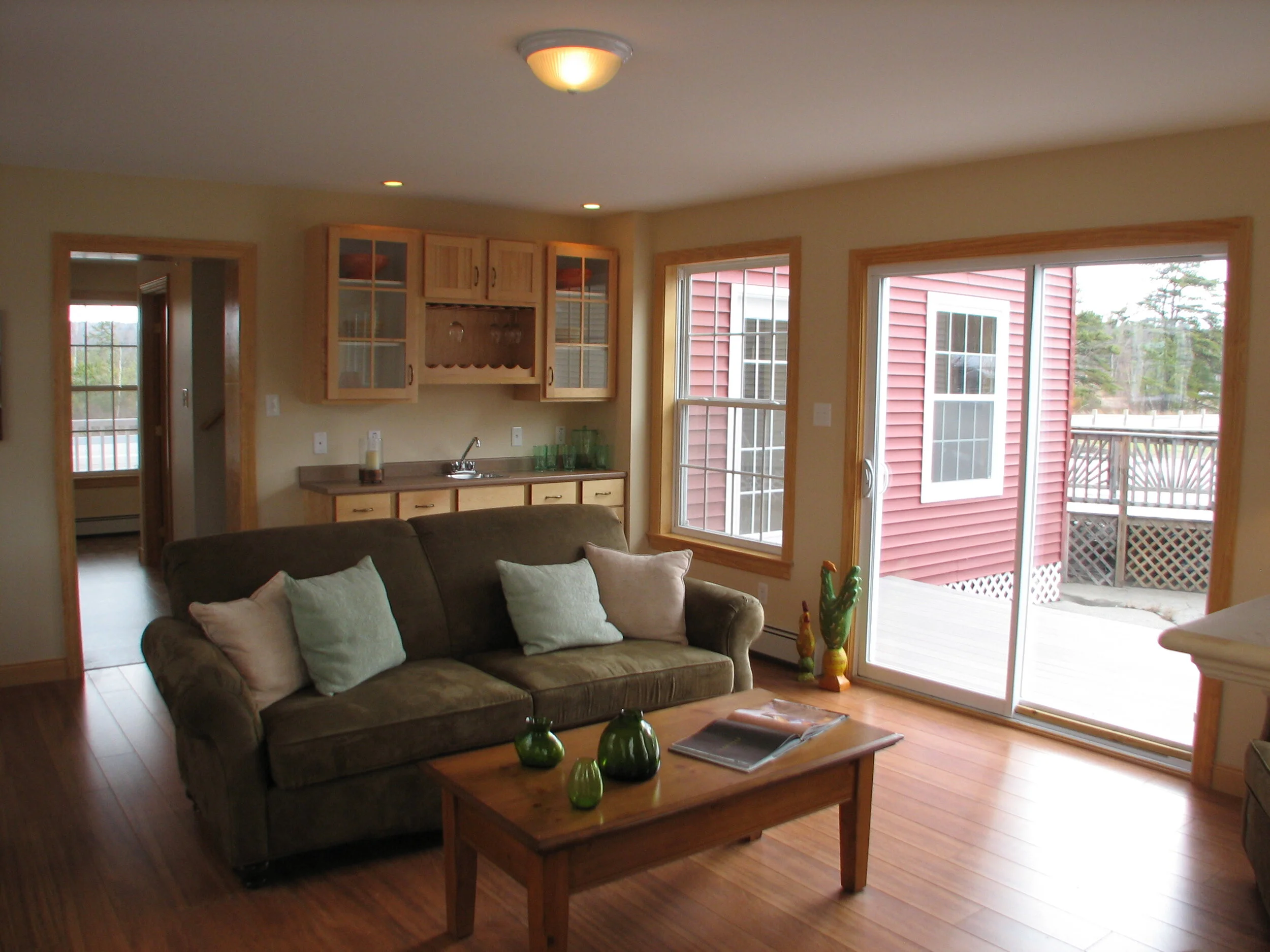 Family room looking back into front entry with snack bar and sliding glass door onto back deck.