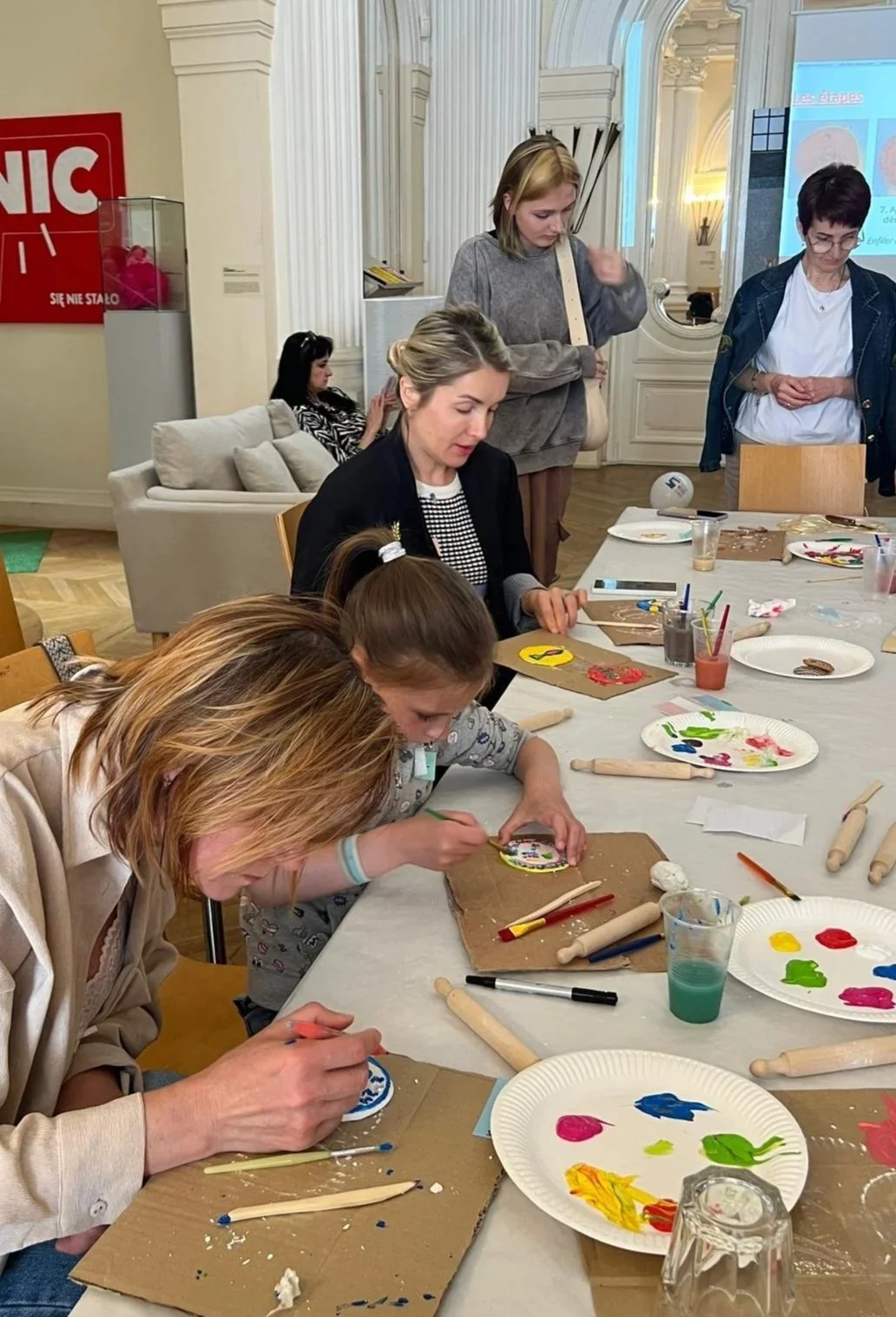 Enfants et parents participant à un atelier Artora sur l’histoire et les valeurs des Jeux Olympiques, mêlant activités culturelles et créatives.
