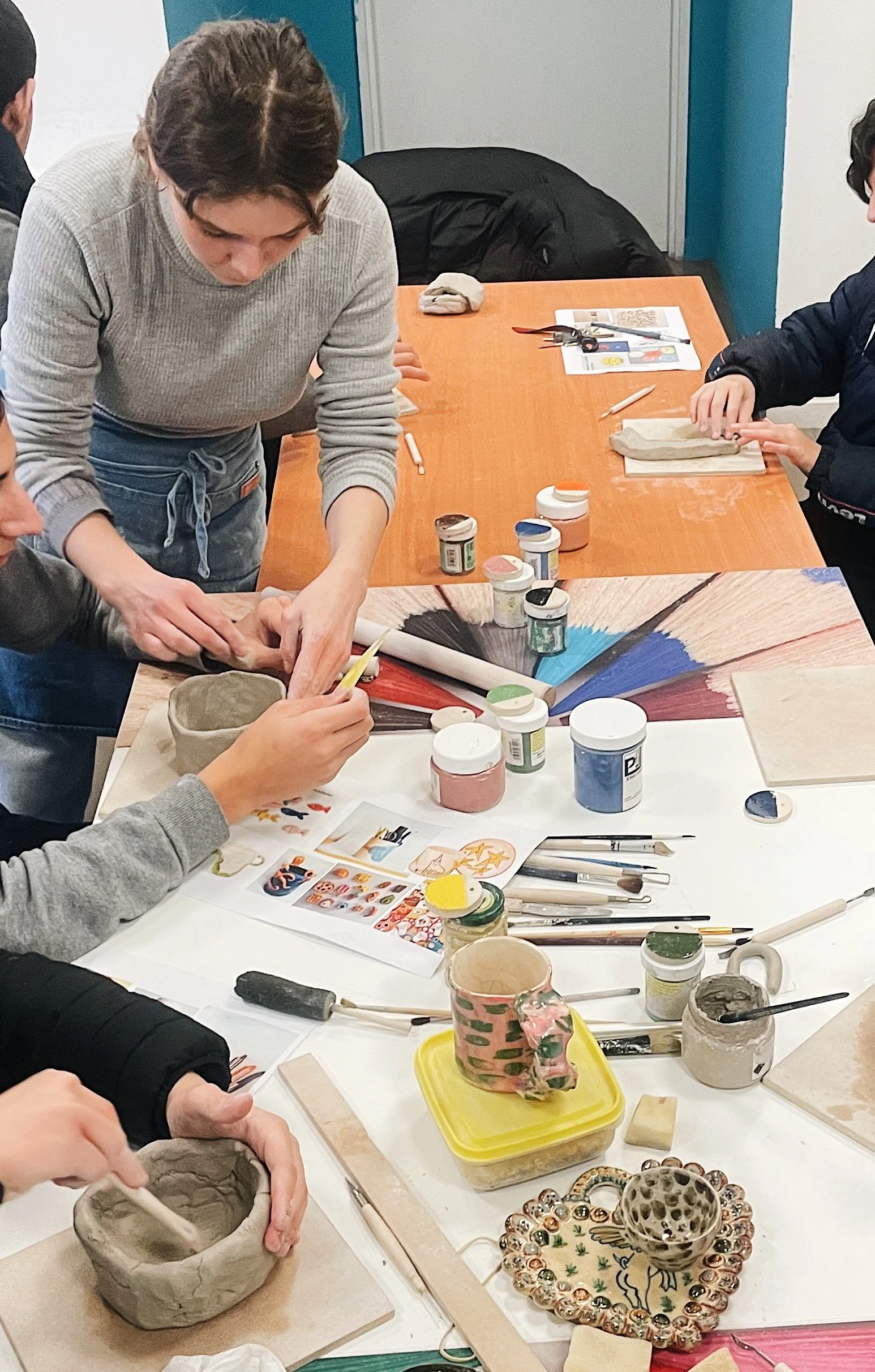 Adolescents participant à un atelier de sculpture animé par Artora dans un centre éducatif fermé, accompagné par des médiateurs.