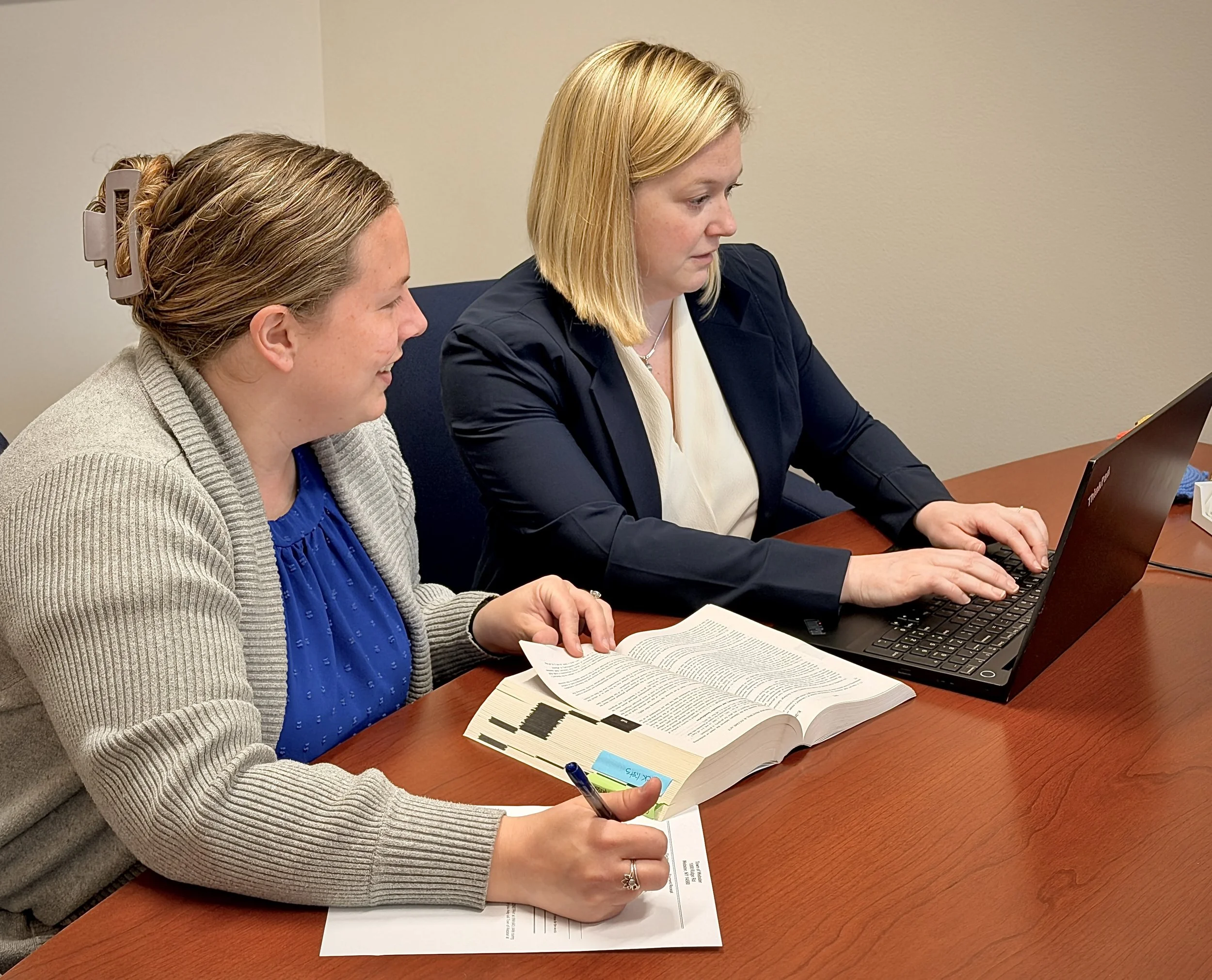 Kate and Daniele working at a table with a laptop and books