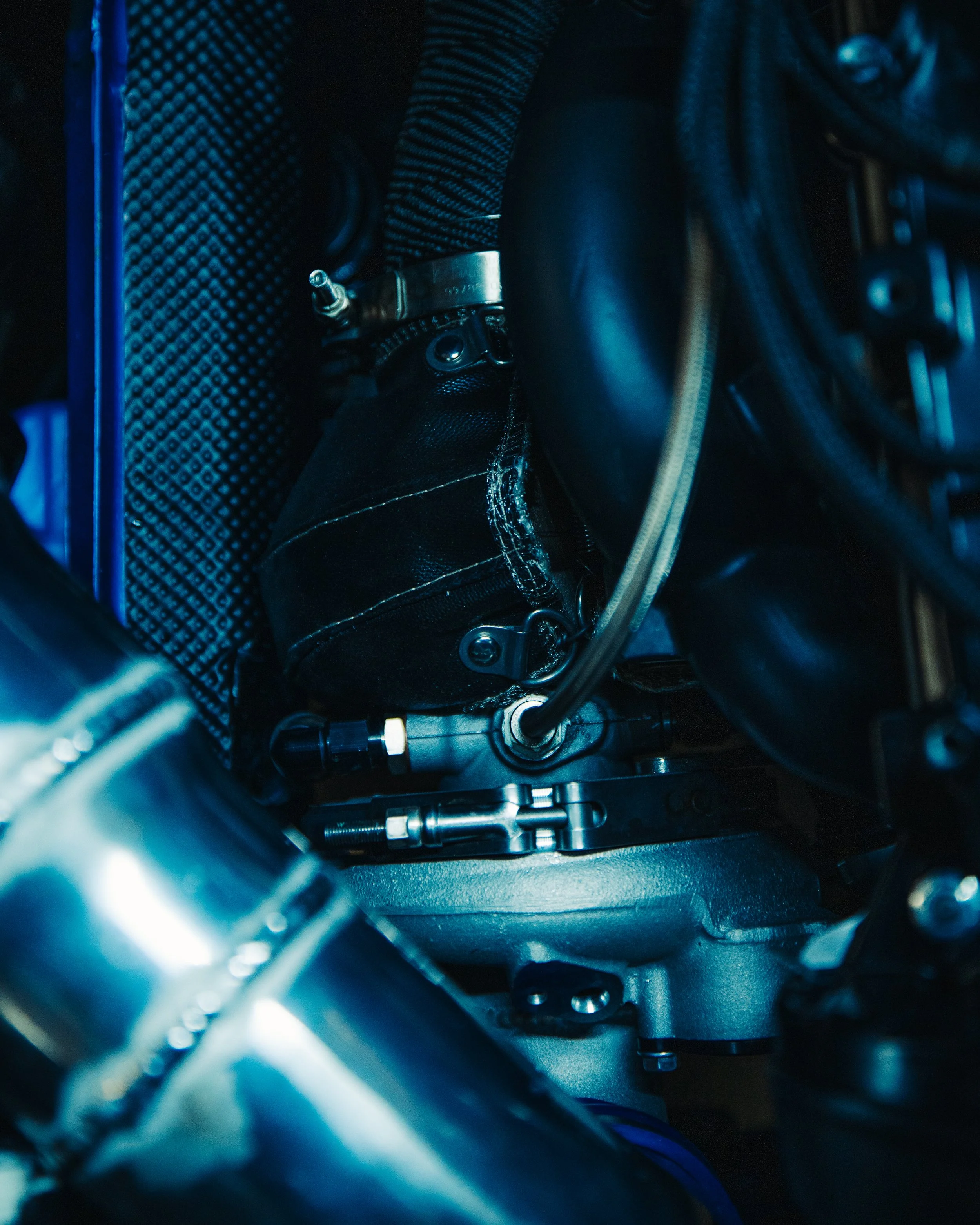 Close-up of a motorcycle engine with visible bolts, tubes, and metallic components.