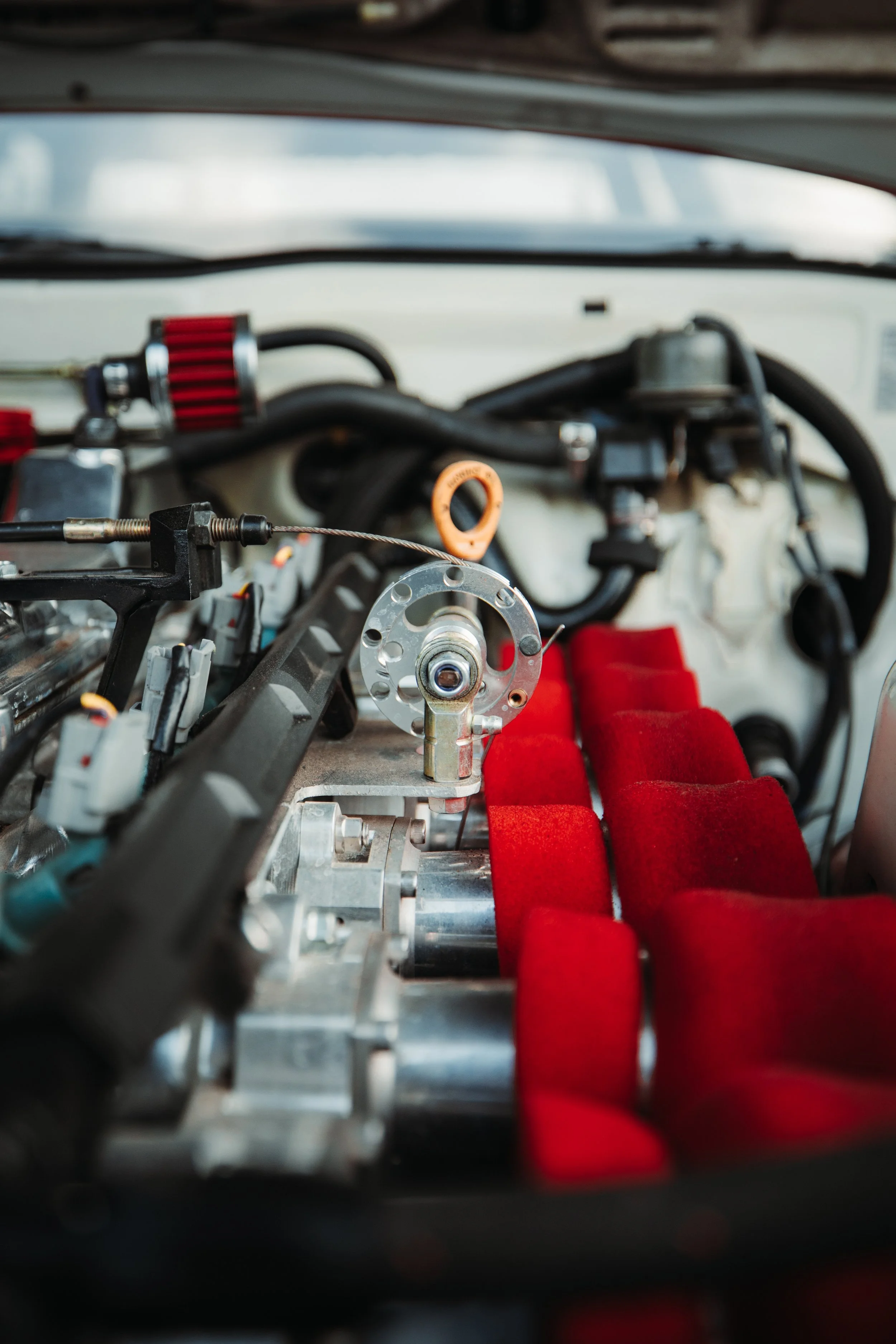 Close-up view of a race car's interior showing engine components, red seats, and various mechanical parts.