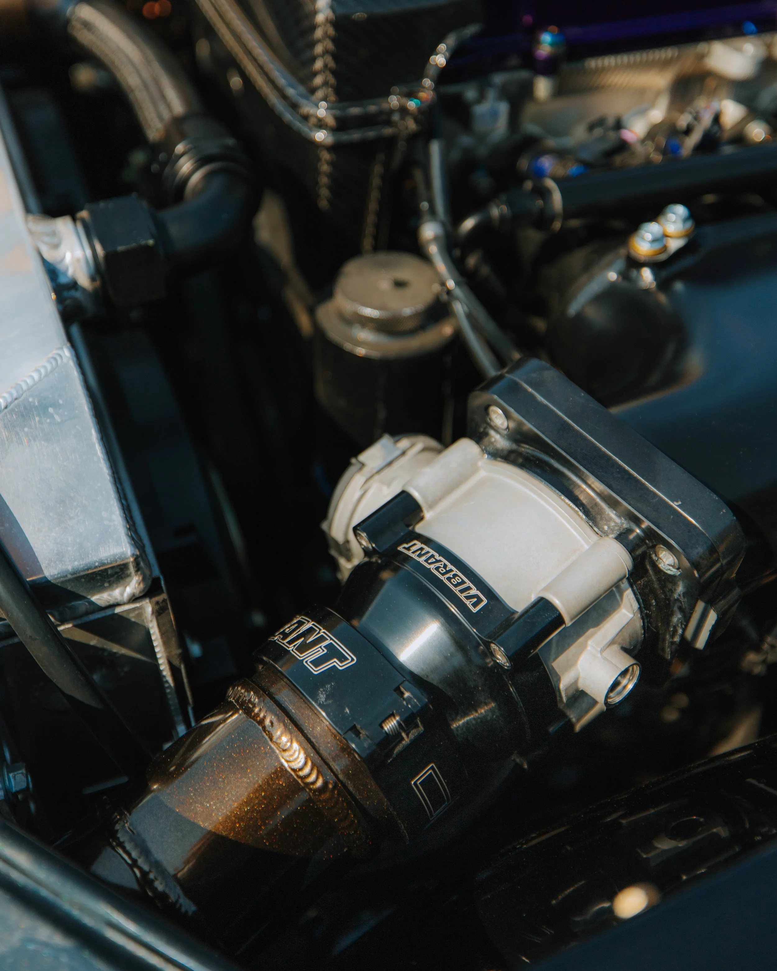Close-up of a vintage car engine with a visible black and silver supercharger labeled 'Vulcan'.