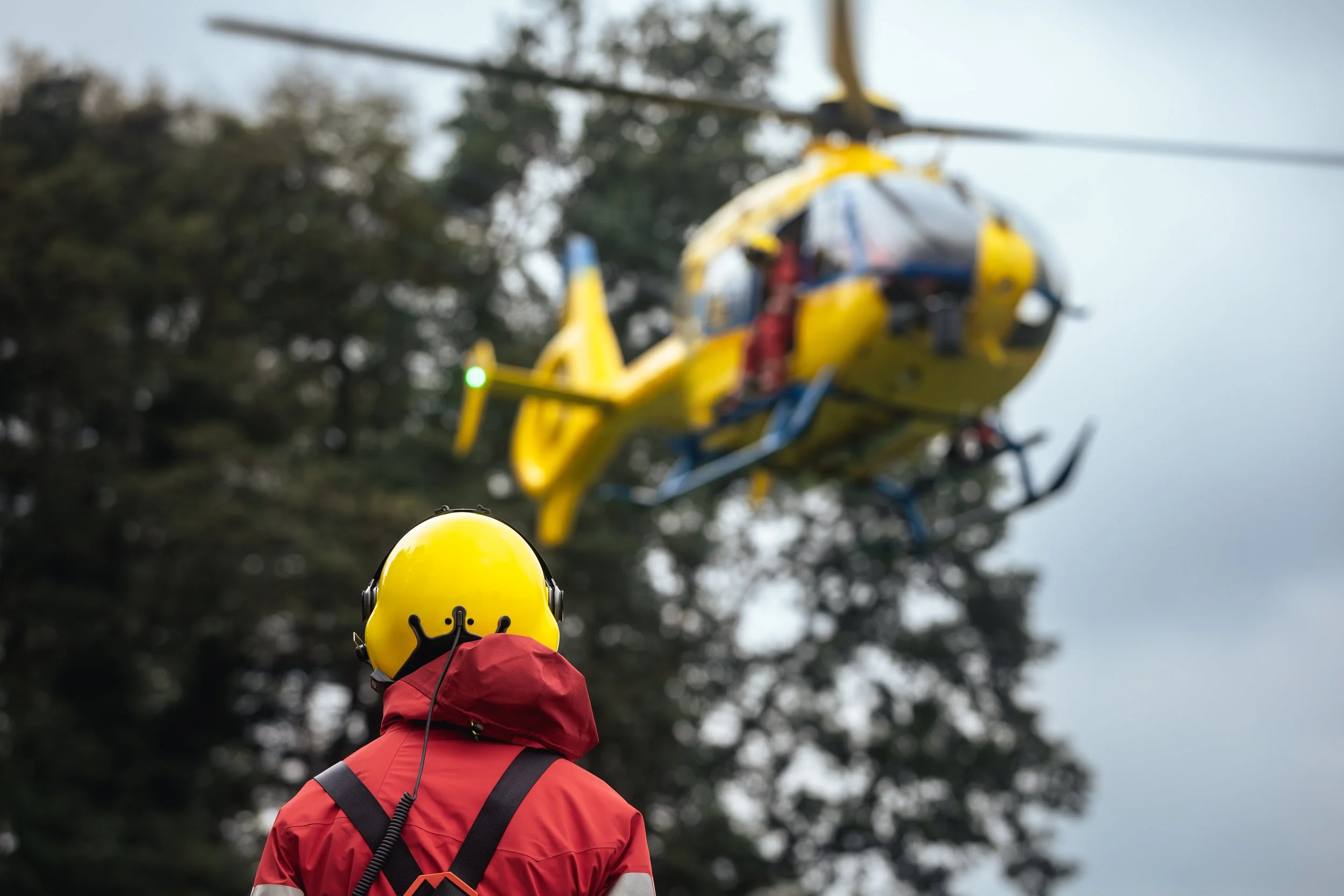 Rettungssanitäter vor einem abgestürzten Rettungshubschrauber in einem Wald