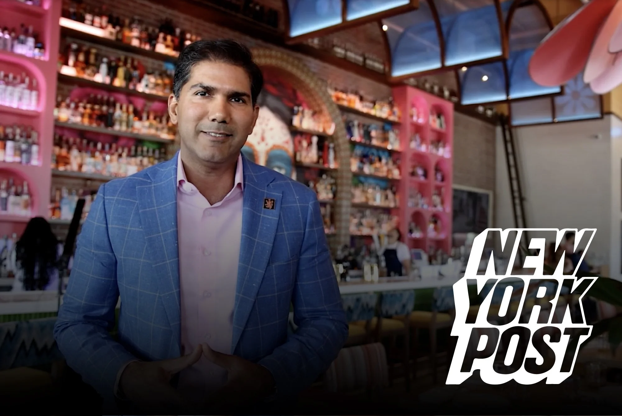 A man in a blue blazer and pink shirt standing inside a colorful bar or restaurant with shelves of bottles in the background, and the words "New York Post" overlayed.