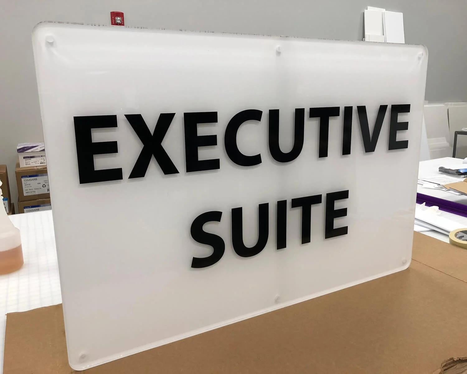 Sign with black letters on a white background reading 'EXECUTIVE SUITE'.