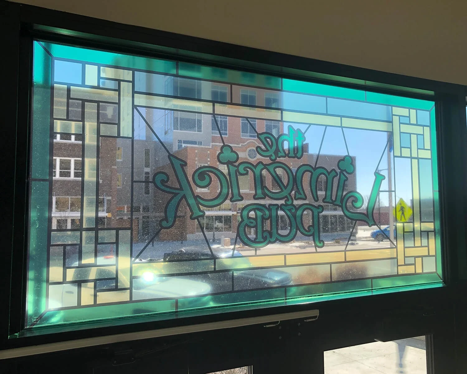 Decorative window sign with stained glass style border reading 'The Architecture Pub'