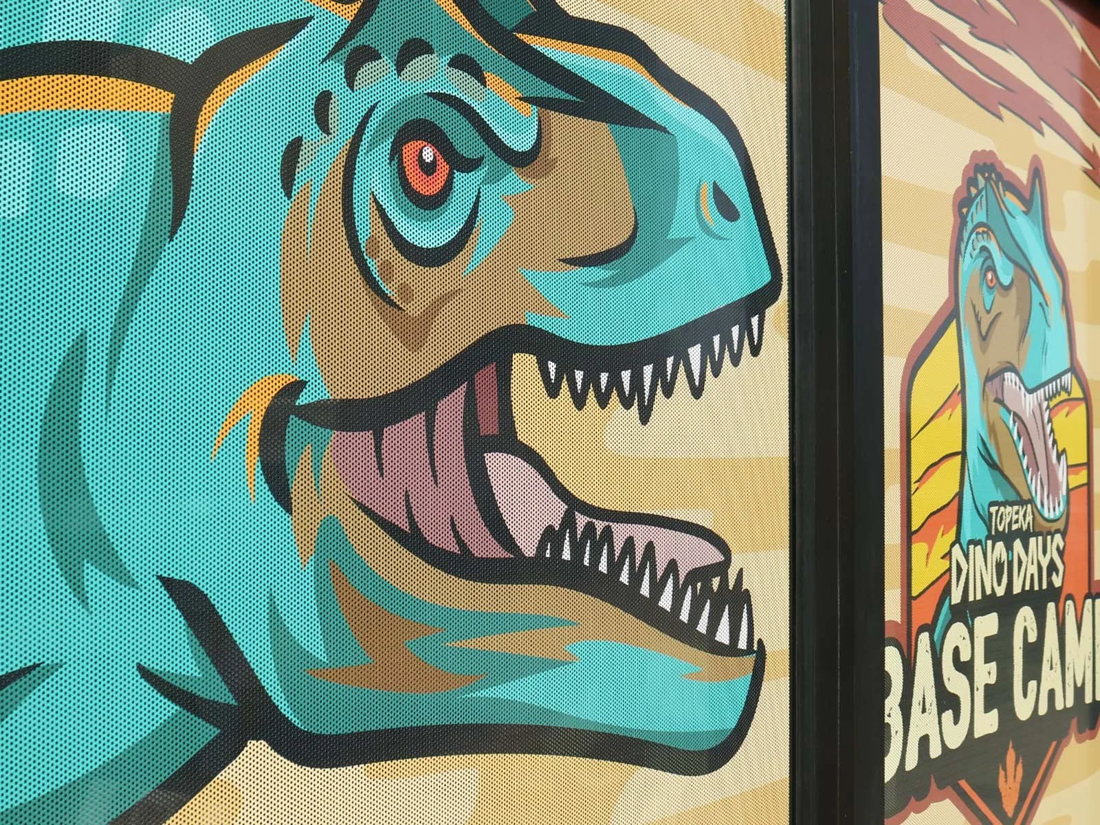 Colorful poster featuring a cartoon dinosaur with sharp teeth, red eyes, and a blue and tan body, promoting 'Topeka Dino Days' and a dinosaur base camp.