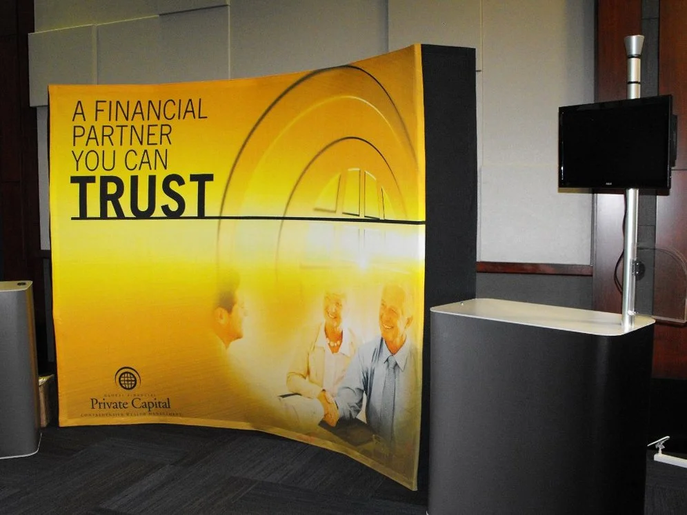 A large yellow and black advert displays the text, 'A Financial Partner You Can Trust,' with an image of three smiling professionals shaking hands, and the logo 'Private Capital' at the bottom left.