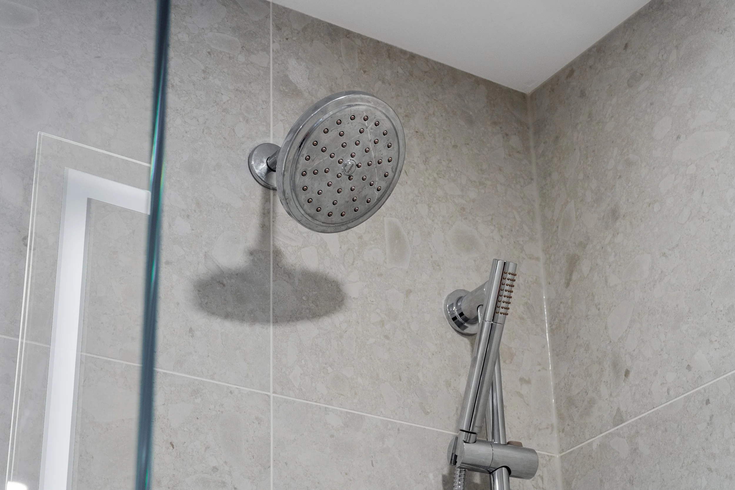 Showerhead and handheld shower in a tiled shower.  The Riverbend Condos, Huntsville, Muskoka.