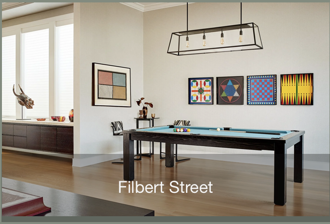Filbert Street in Pacific Heights is a game room with a custom pool table, colorful art wall, modern black pendant light, and warm wood floors, designed as a relaxed entertainment space in a Marin County home.