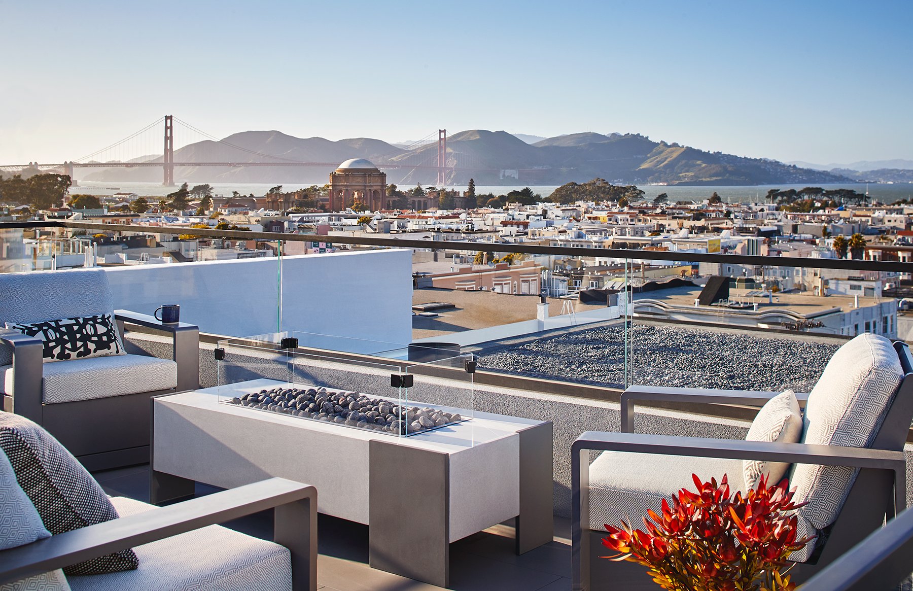 Filbert Street Pacific Heights rooftop terrace overlooking San Francisco with lounge seating and a fire pit, capturing Golden Gate Bridge views and modern luxury outdoor living.